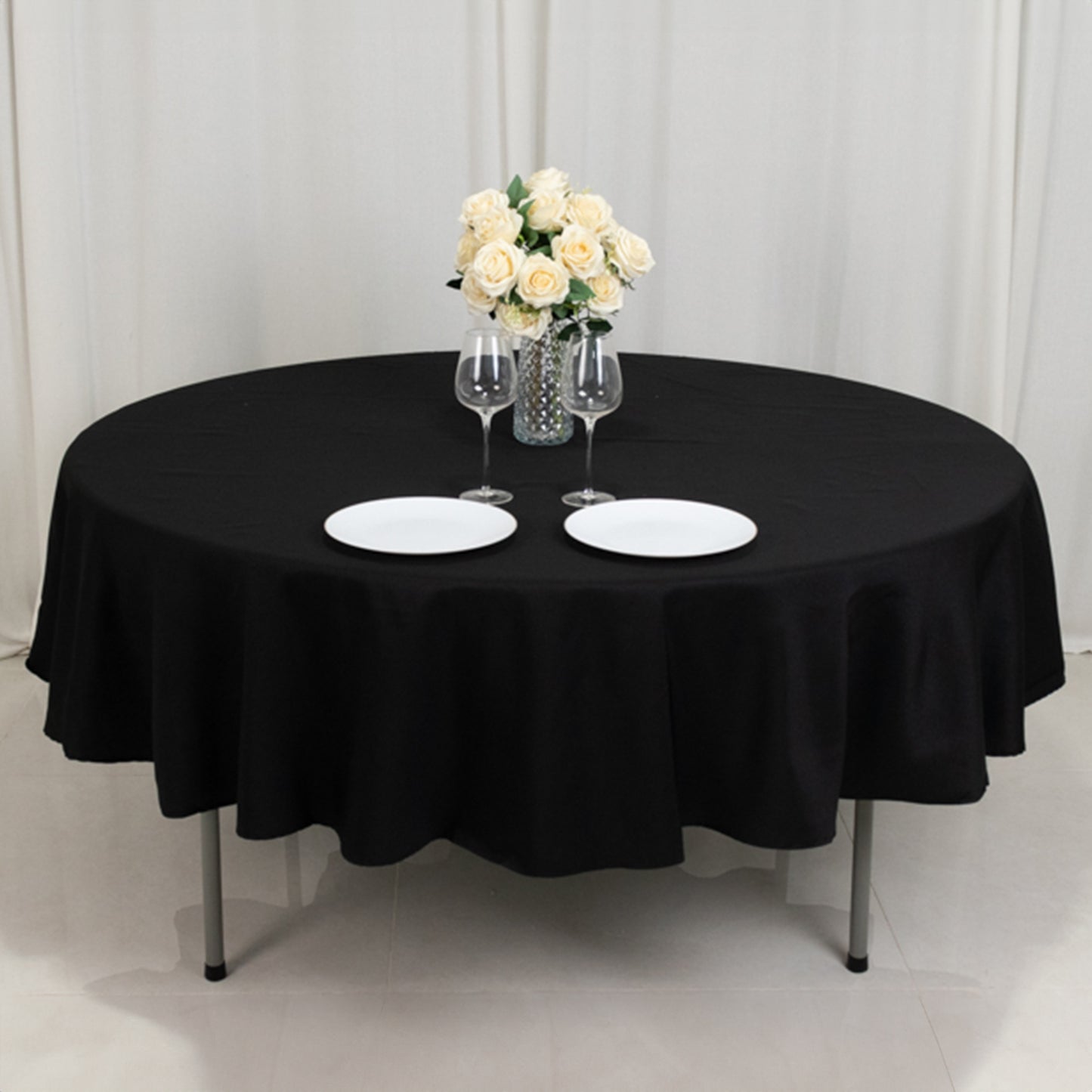 Black fire retardant round tablecloth with elegant table setting.