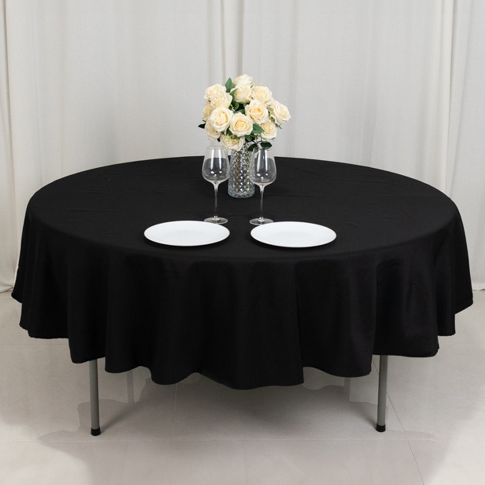 Black fire retardant round tablecloth with elegant table setting.
