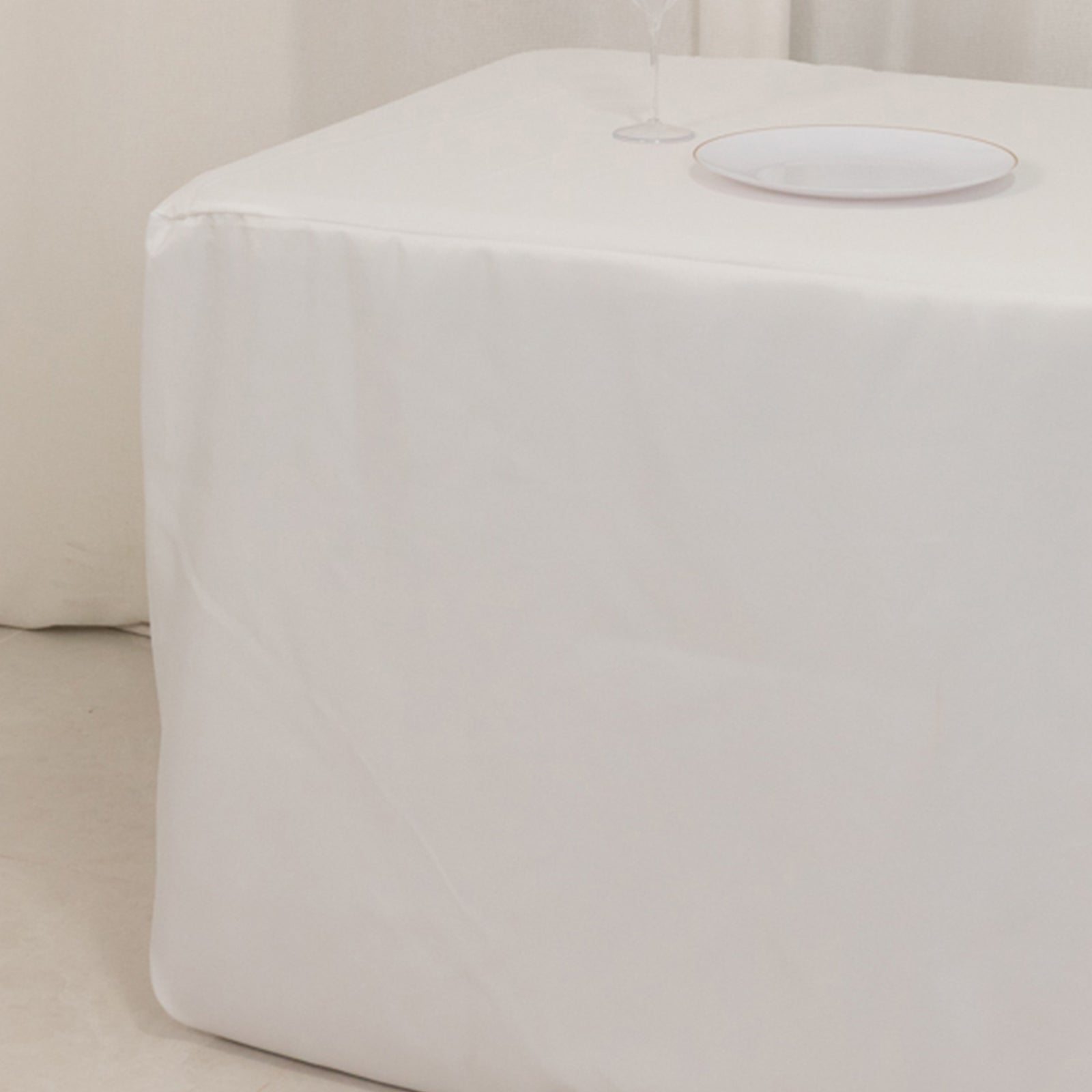 White fitted tablecloth on a rectangular table.