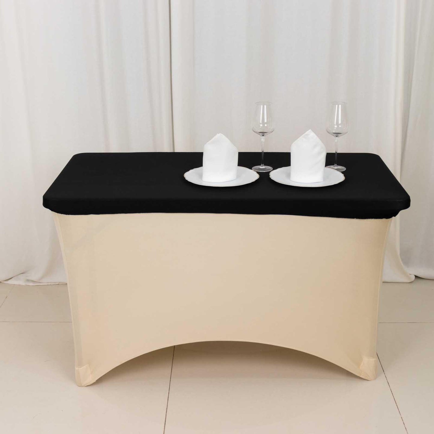 Black fitted tablecloth for 48"x30" tables with elegant white dinnerware.