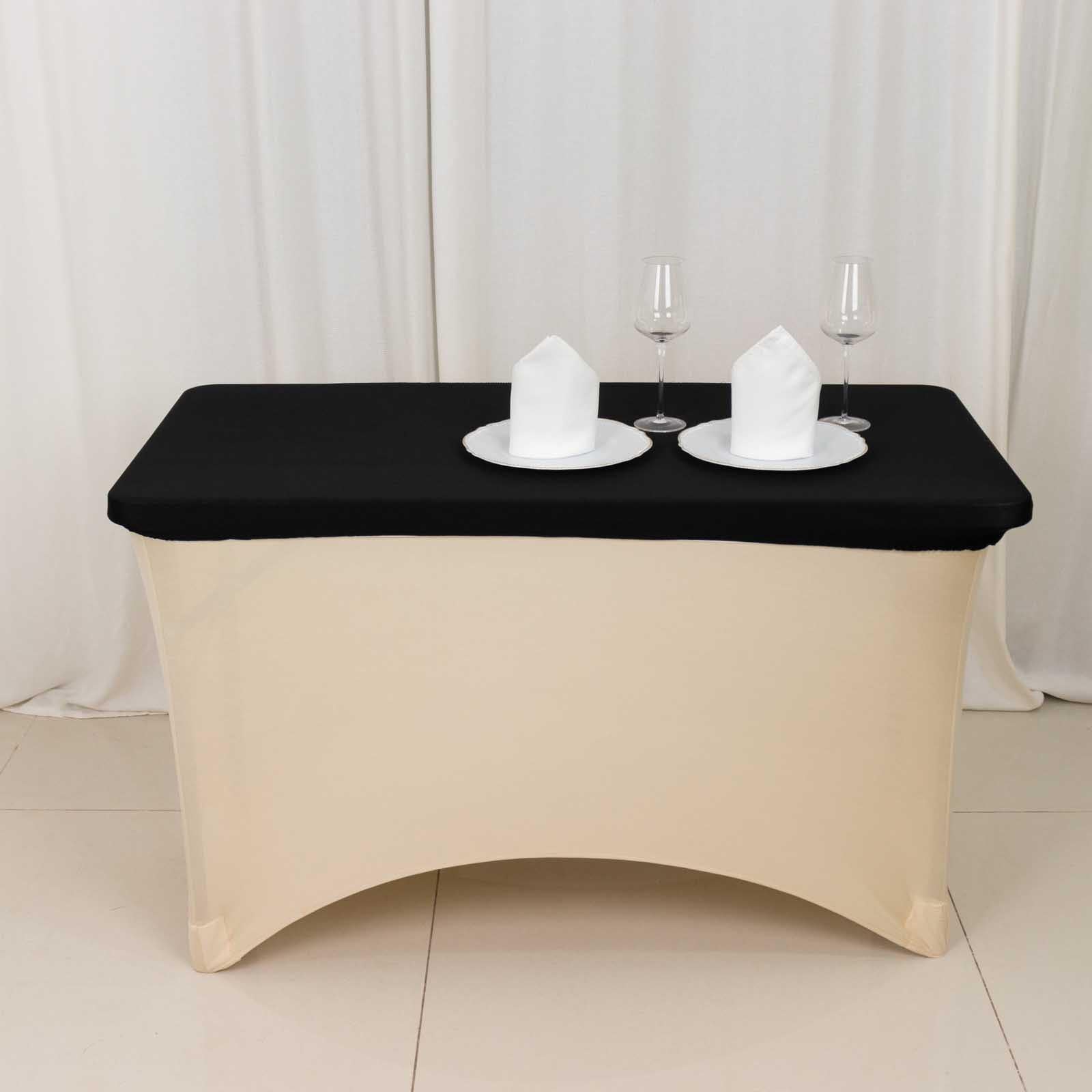 Black fitted tablecloth for 48"x30" tables with elegant white dinnerware.