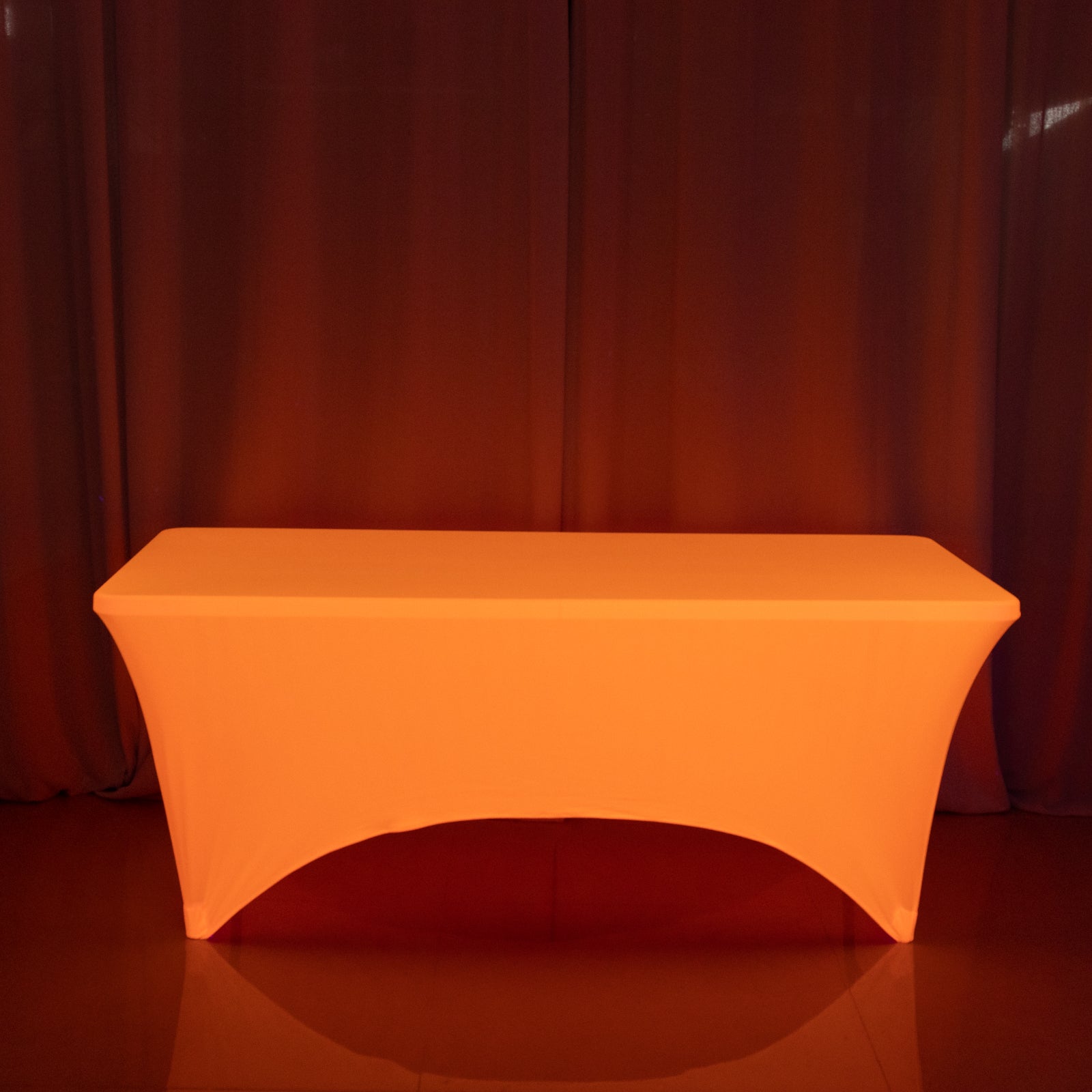Glow neon orange fitted spandex tablecloth on a 6ft rectangle table.