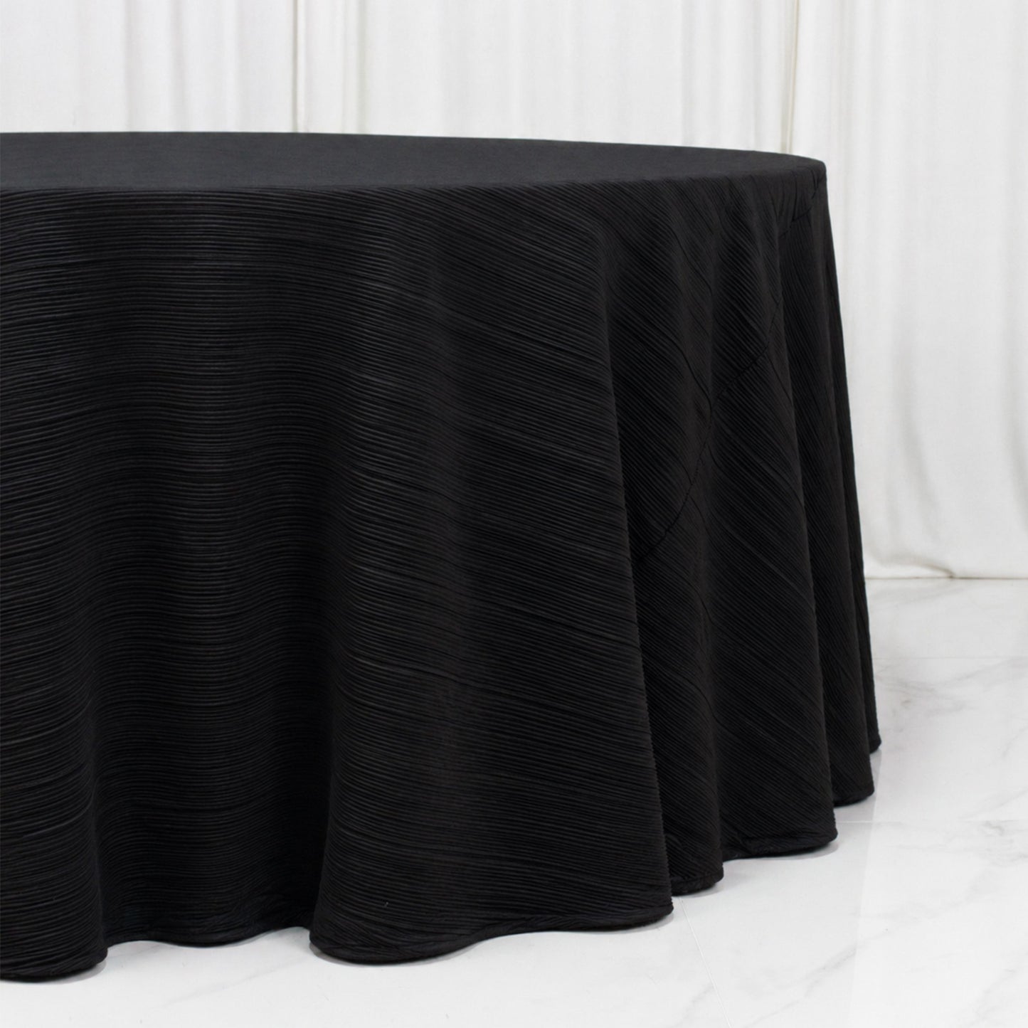 Black accordion pleated scuba tablecloth 120" round, wrinkle free and stain resistant.