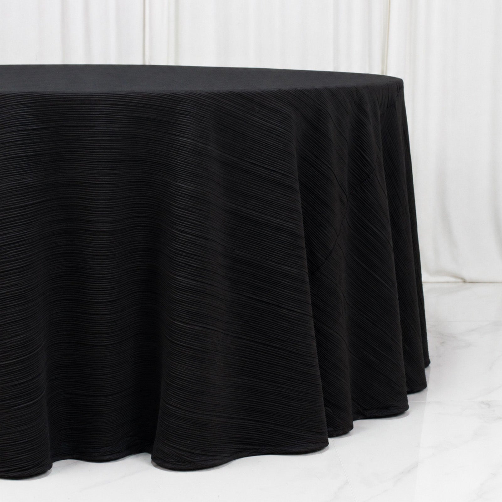 Black accordion pleated scuba tablecloth 120" round, wrinkle free and stain resistant.