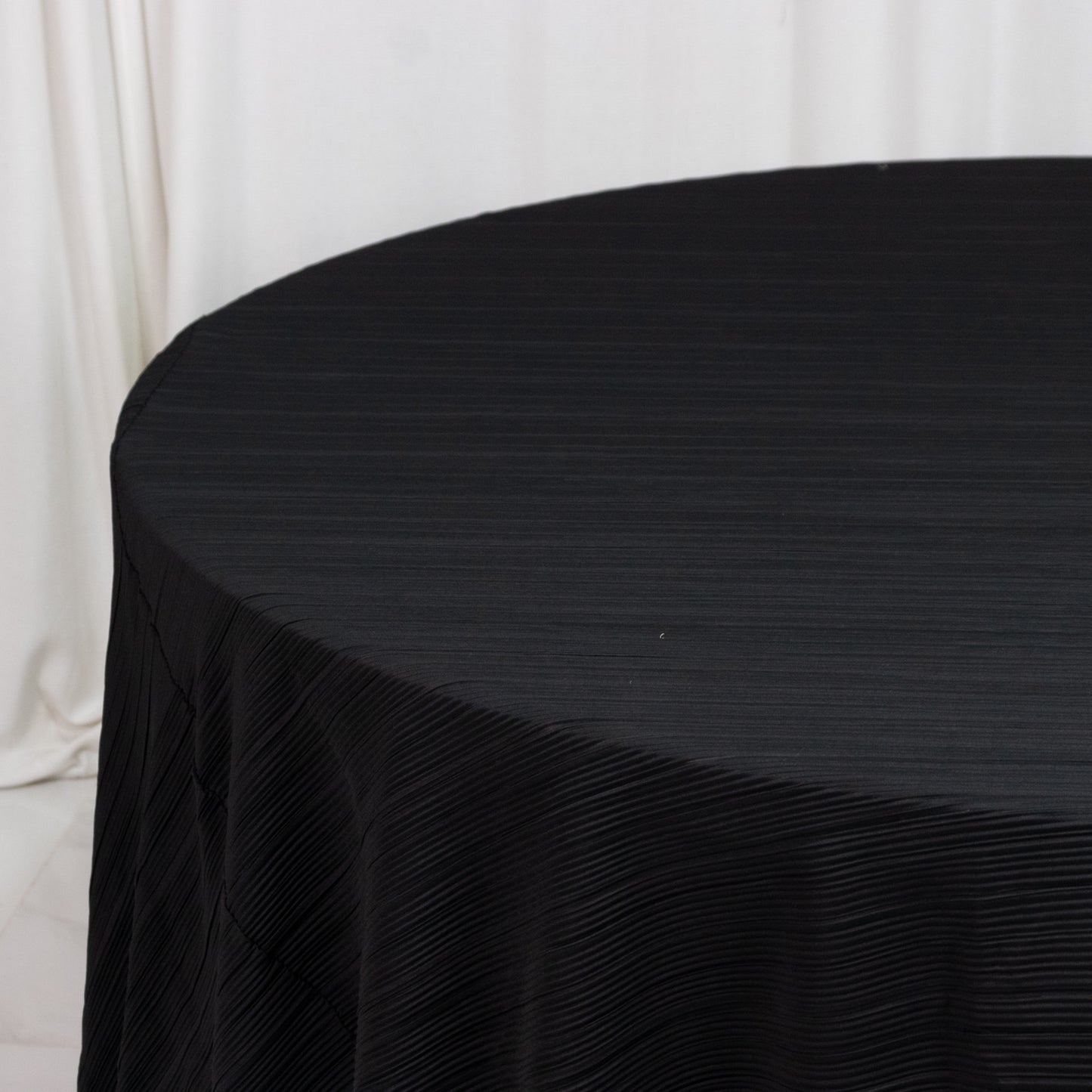 Black accordion pleated scuba tablecloth, 120" round, wrinkle-free and stain-resistant.