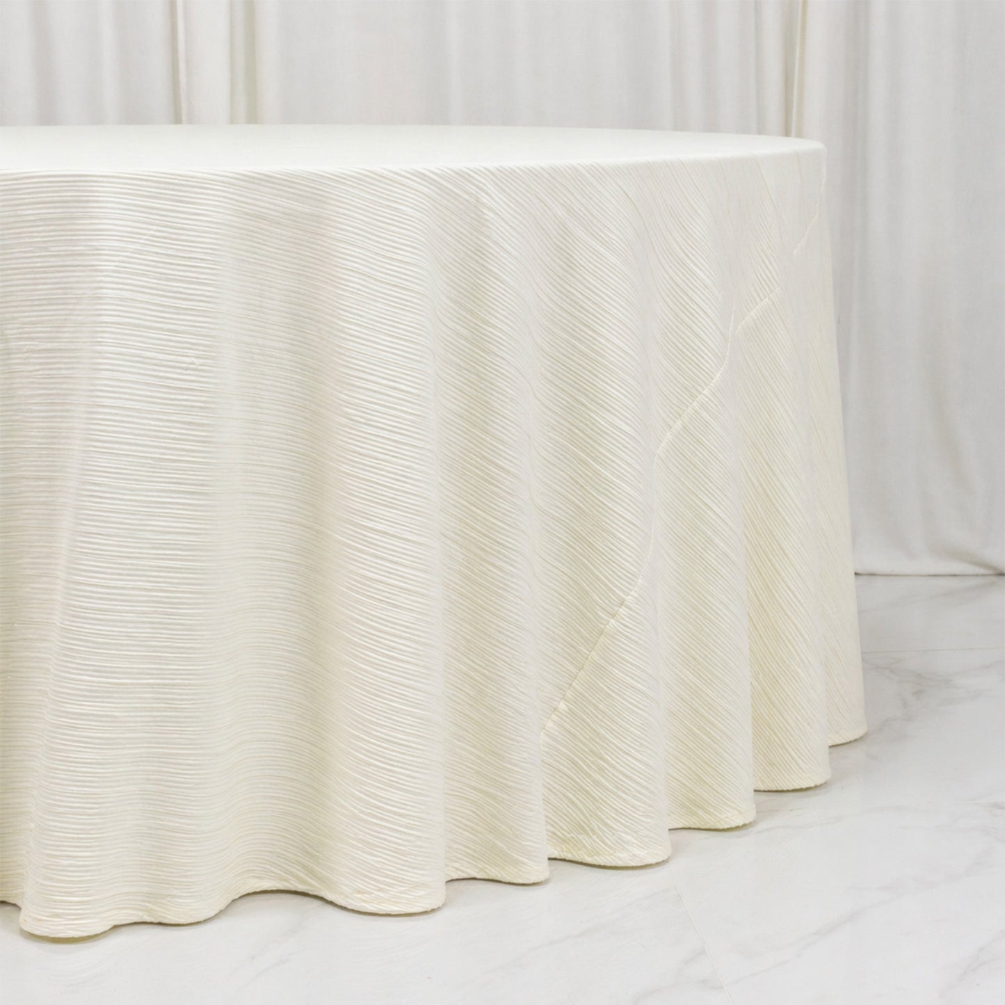 Ivory accordion pleated scuba tablecloth 120" round, wrinkle-free and stain-resistant.