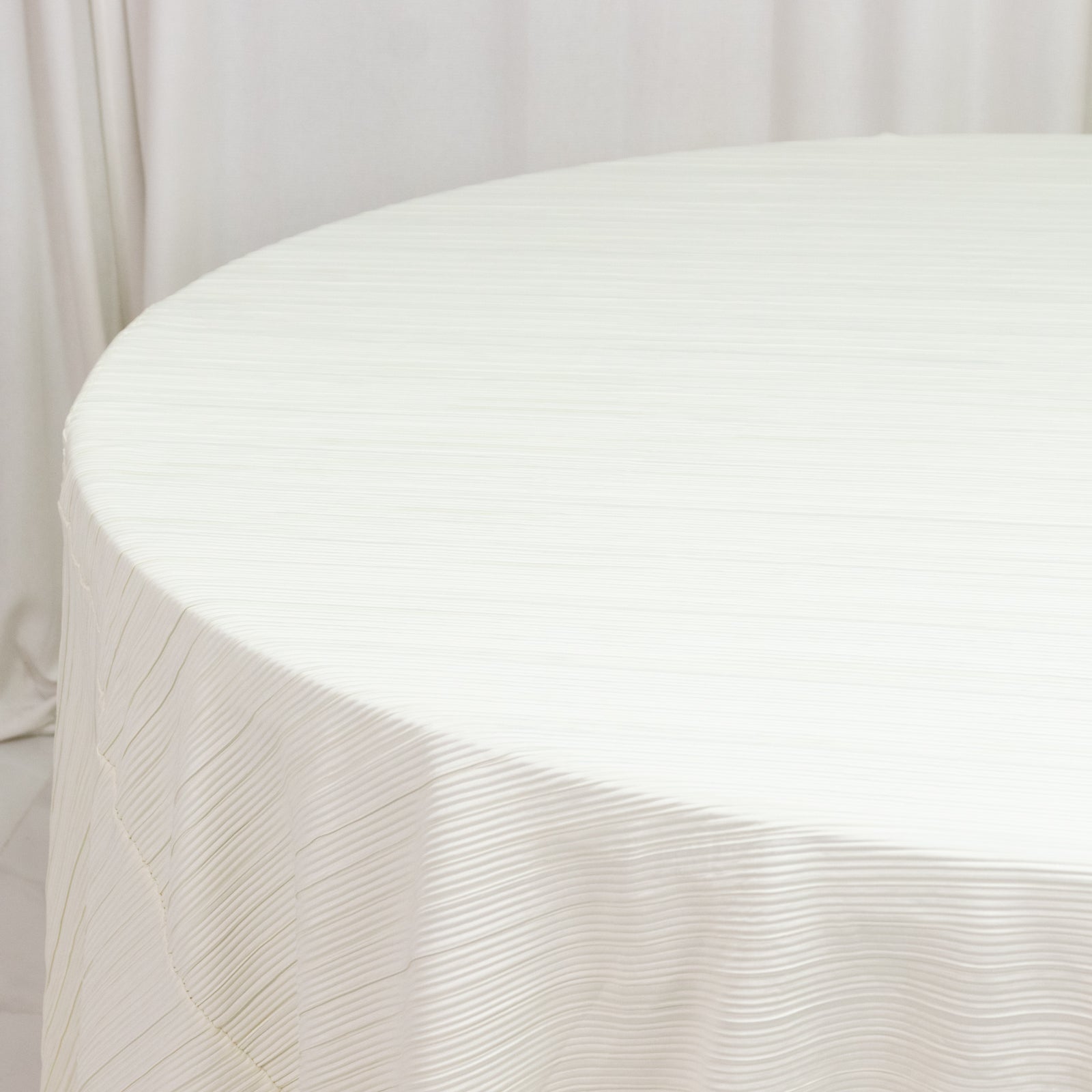 Ivory accordion pleated scuba tablecloth, 120" round, wrinkle-free and stain-resistant.