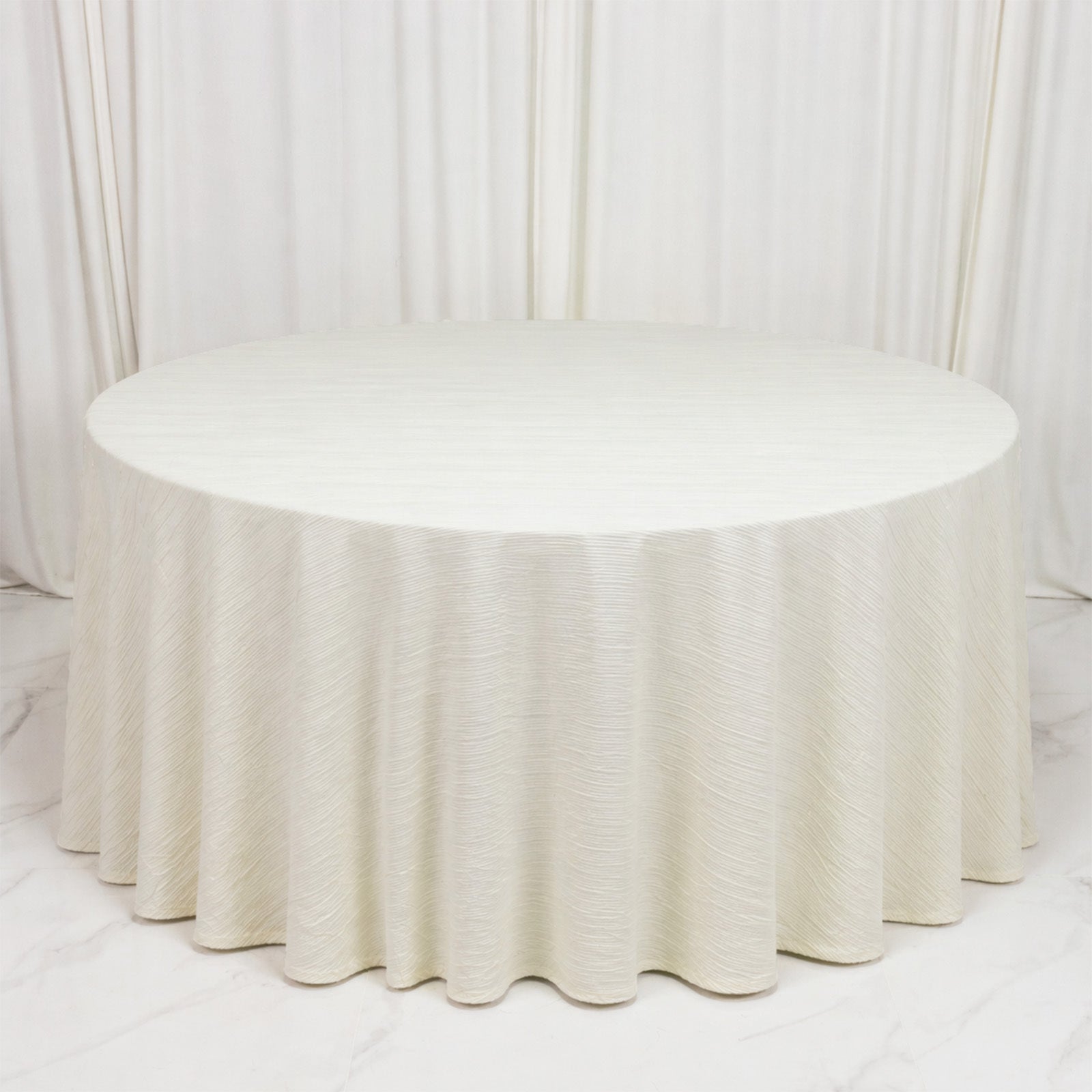 Ivory accordion pleated scuba tablecloth, 120" round, wrinkle-free and stain-resistant.