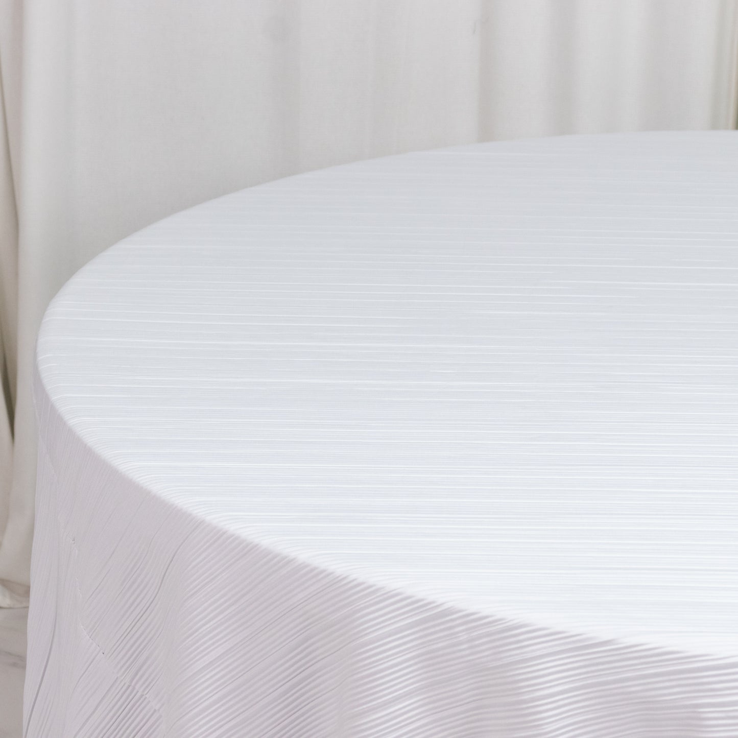 White accordion pleated scuba tablecloth, 120" round, wrinkle-free and stain resistant.
