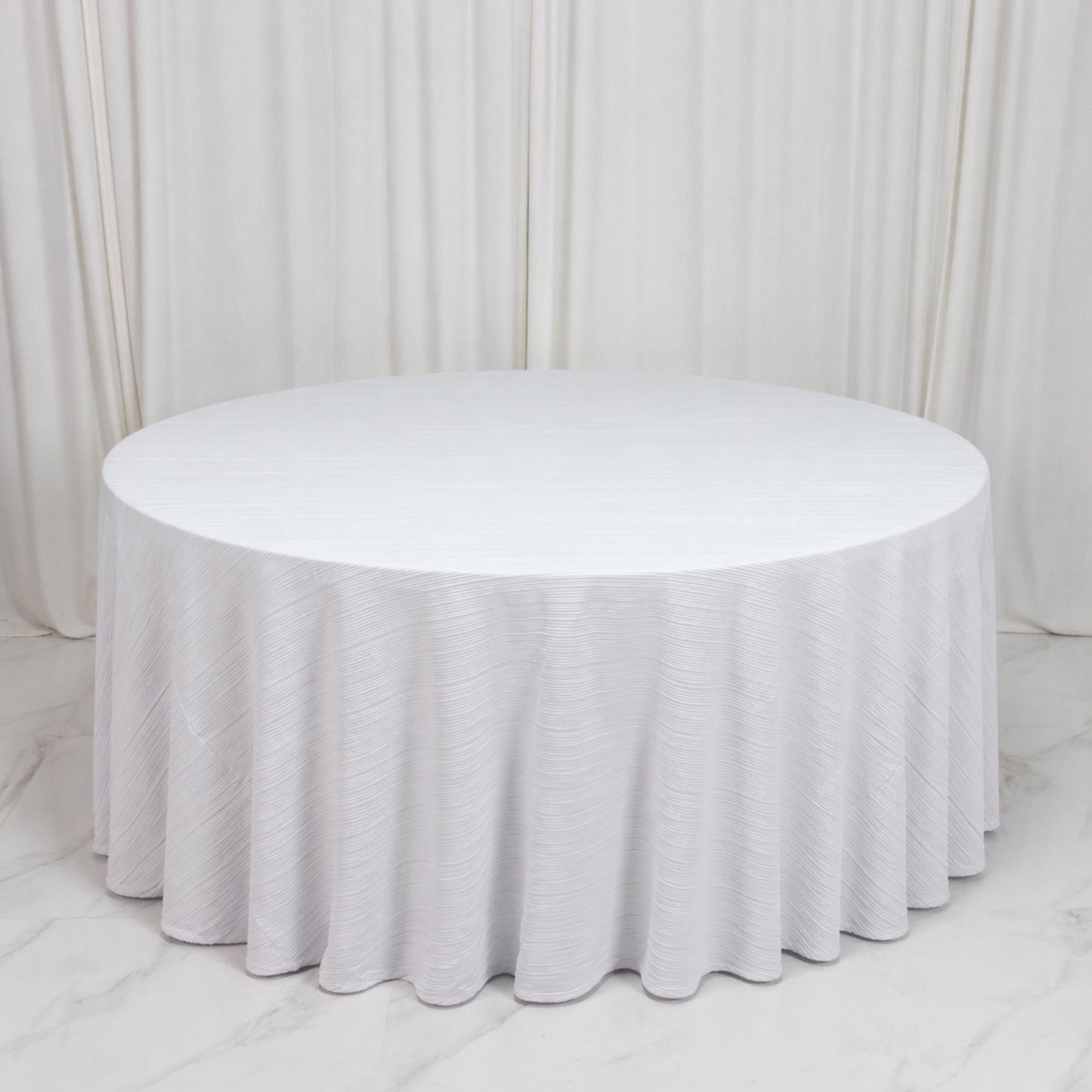 White accordion pleated tablecloth on a round table, wrinkle-free and stain-resistant.