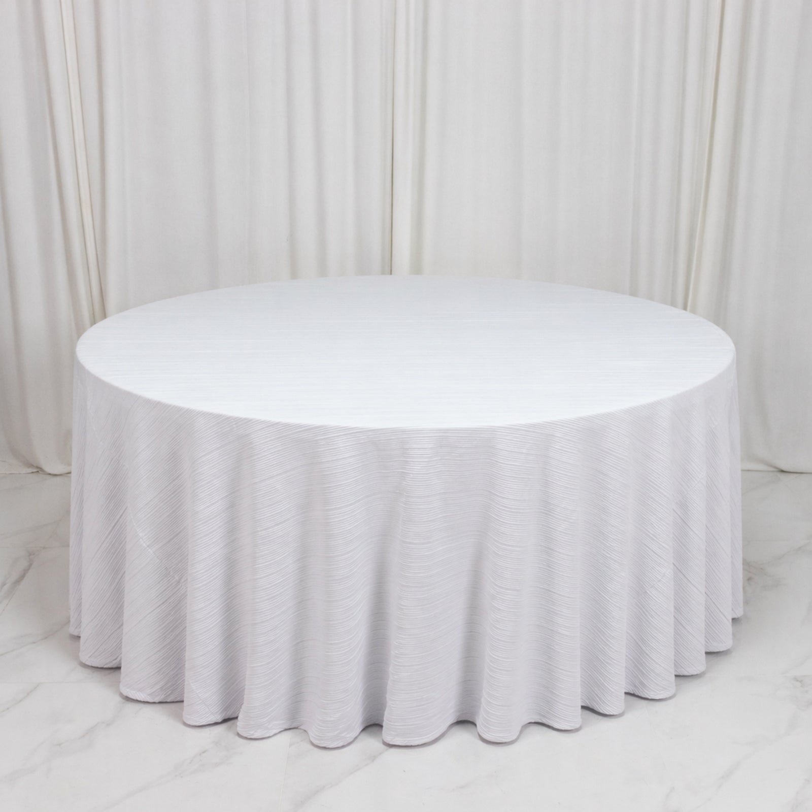 White accordion pleated tablecloth on a round table, wrinkle-free and stain-resistant.