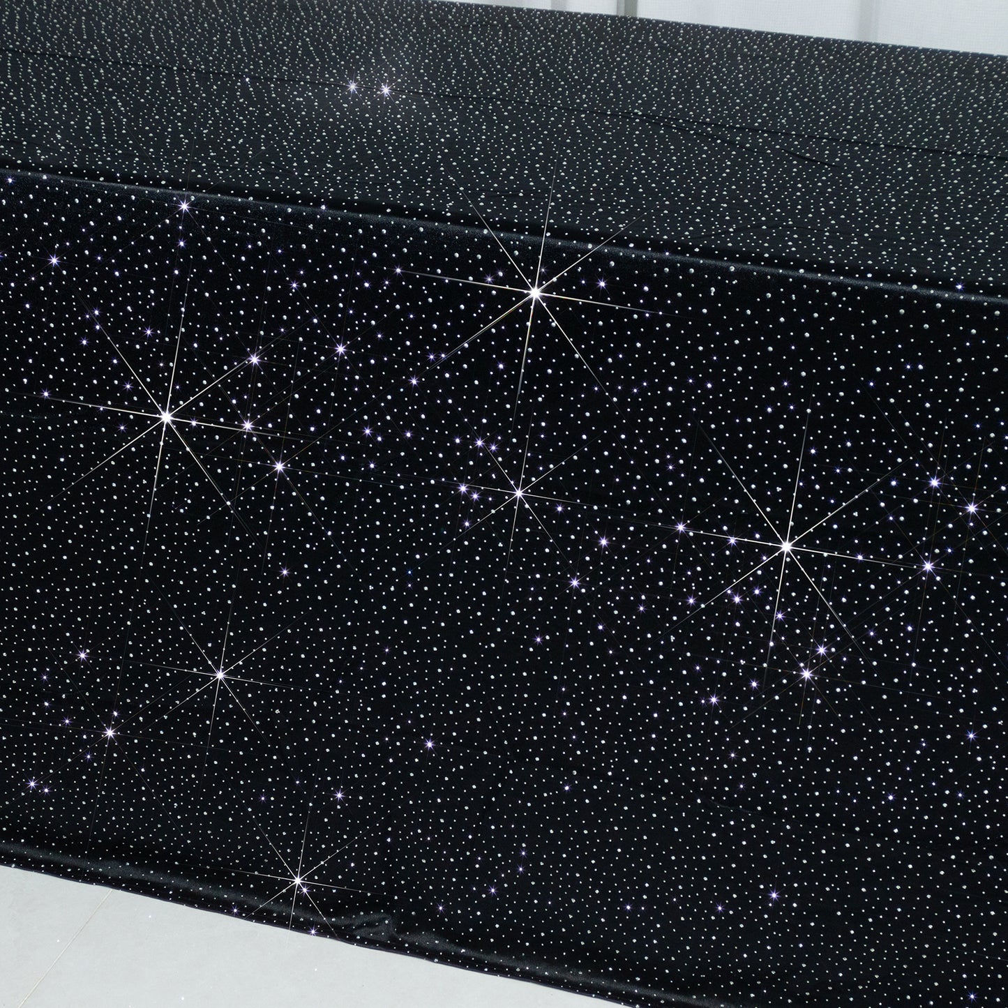 Black rectangular tablecloth with rhinestone accents, seamless and wrinkle-free.