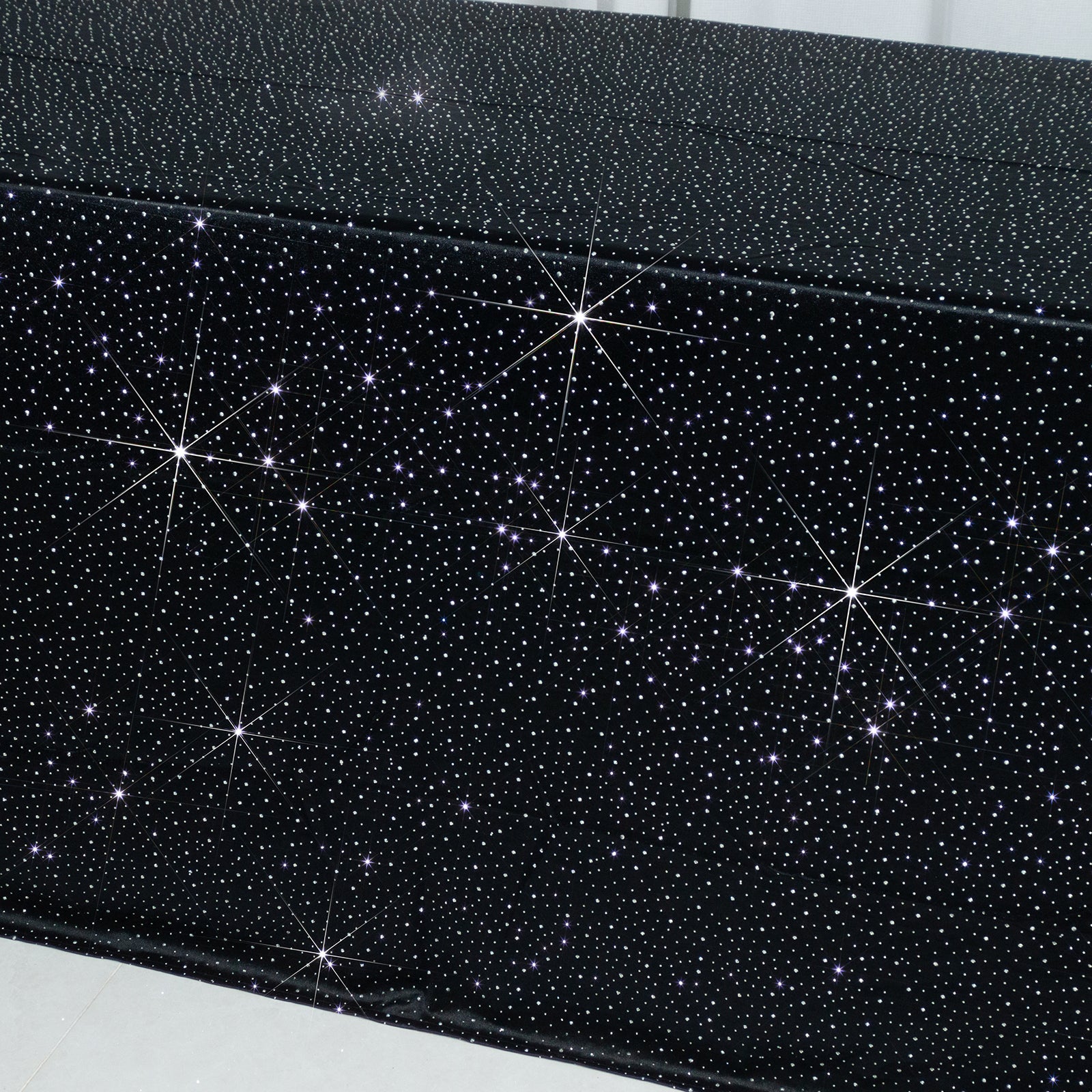 Black rectangular tablecloth with rhinestone accents, seamless and wrinkle-free.