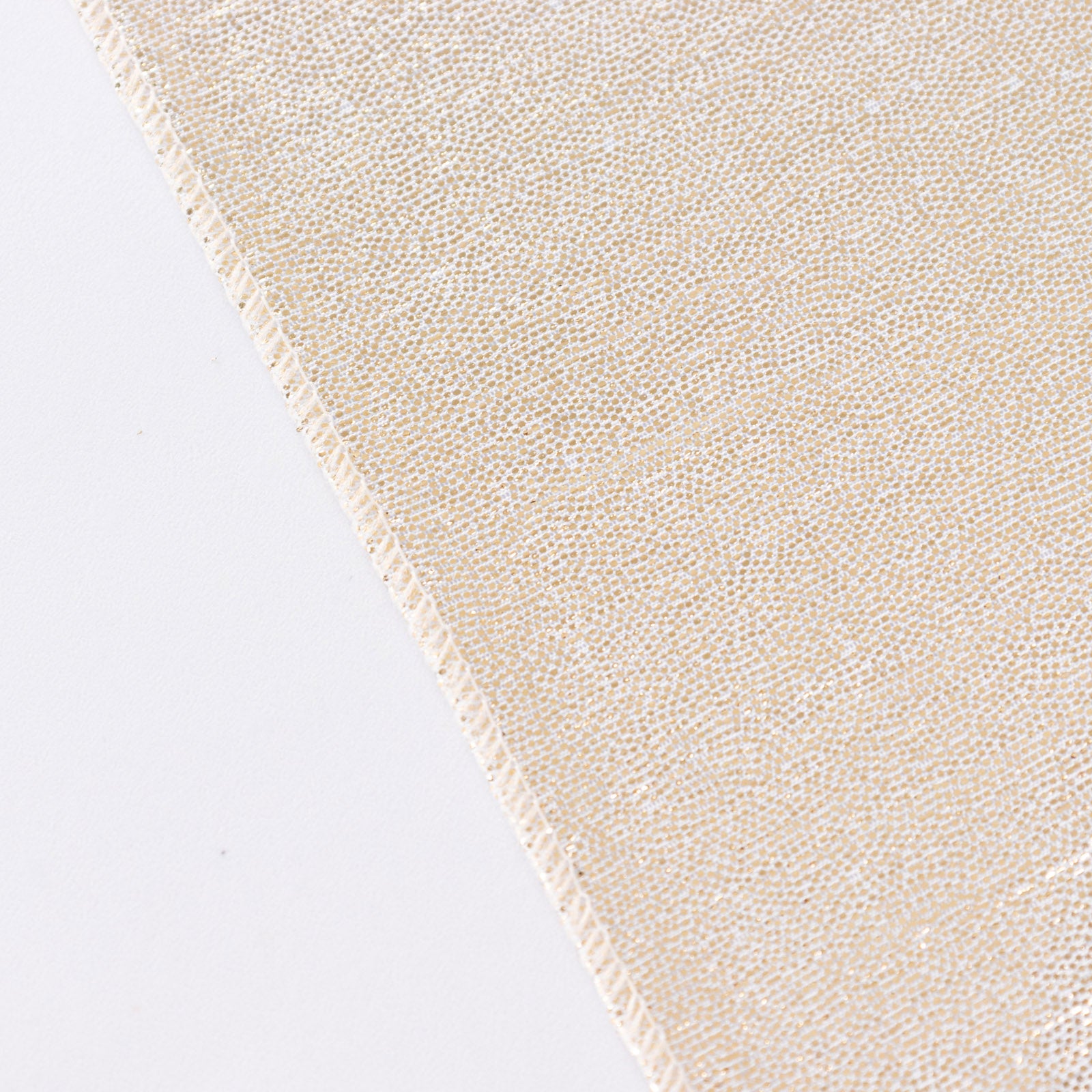 Shiny beige tablecloth with shimmer sequin dots on a white surface.