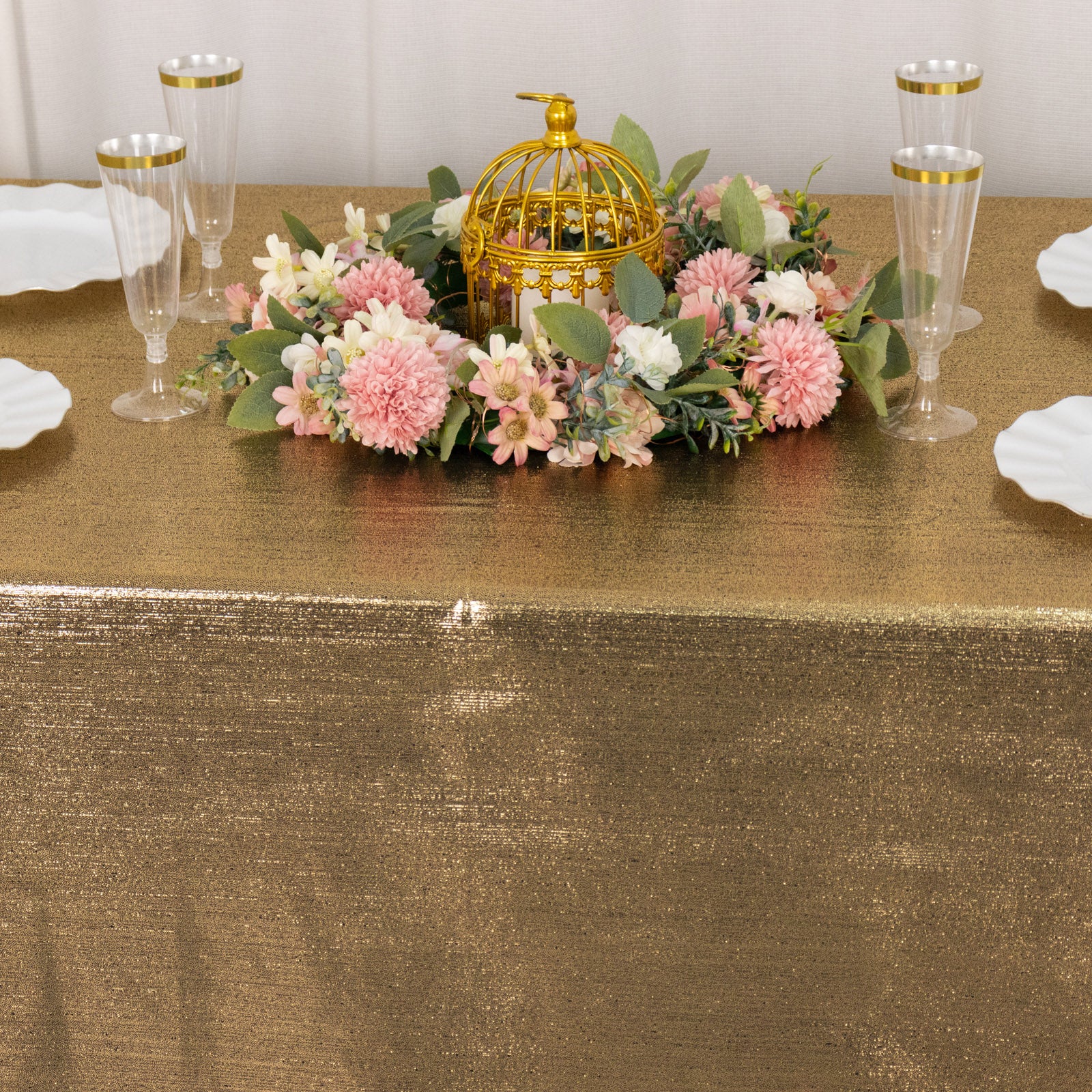 Shiny antique gold tablecloth with shimmer sequin dots on a decorated table.