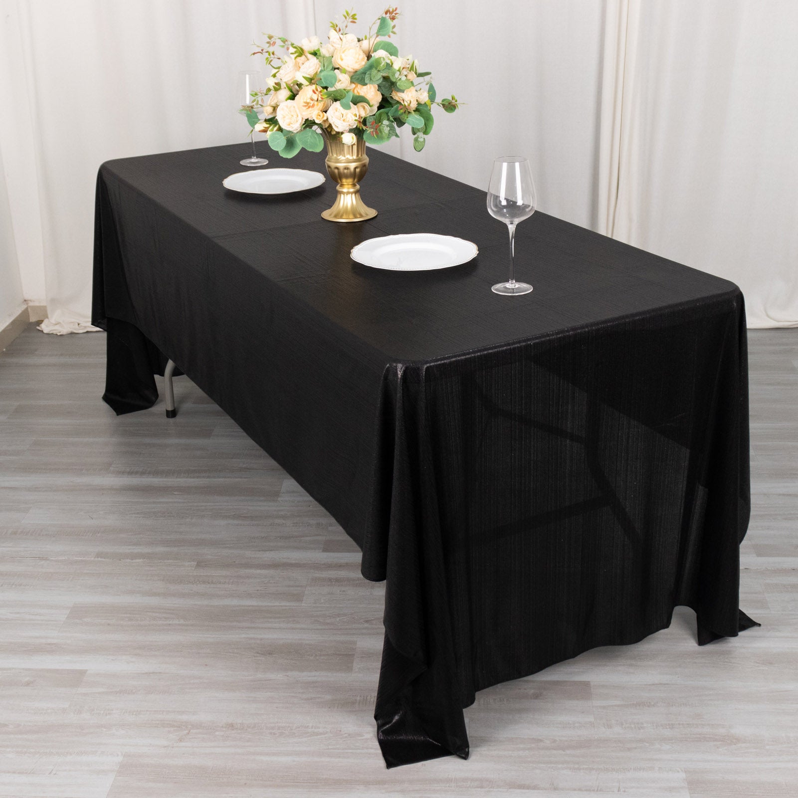 Shiny black polyester tablecloth with shimmer sequin dots on a dining table.