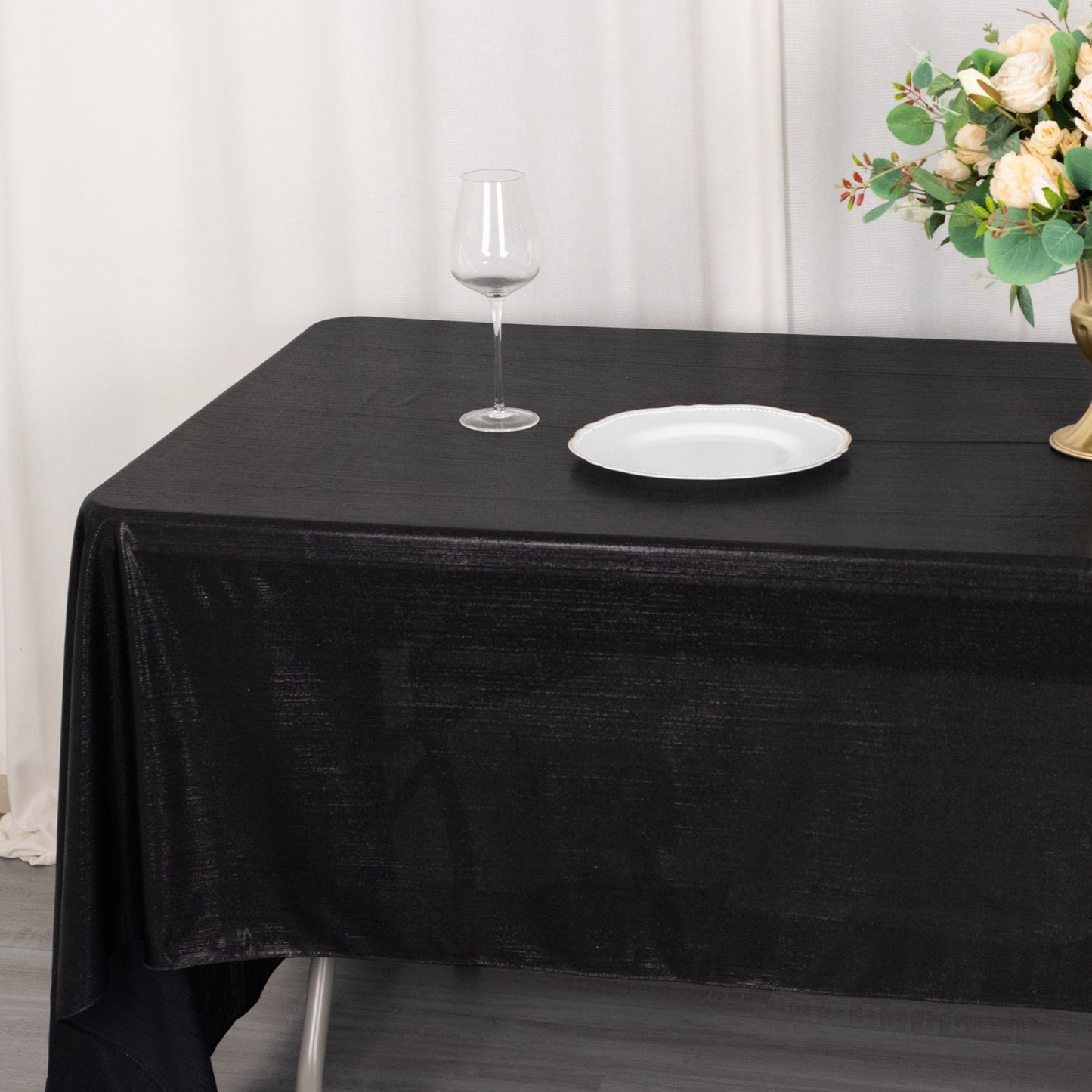 Shiny black polyester tablecloth with shimmer sequin dots on a dining table.