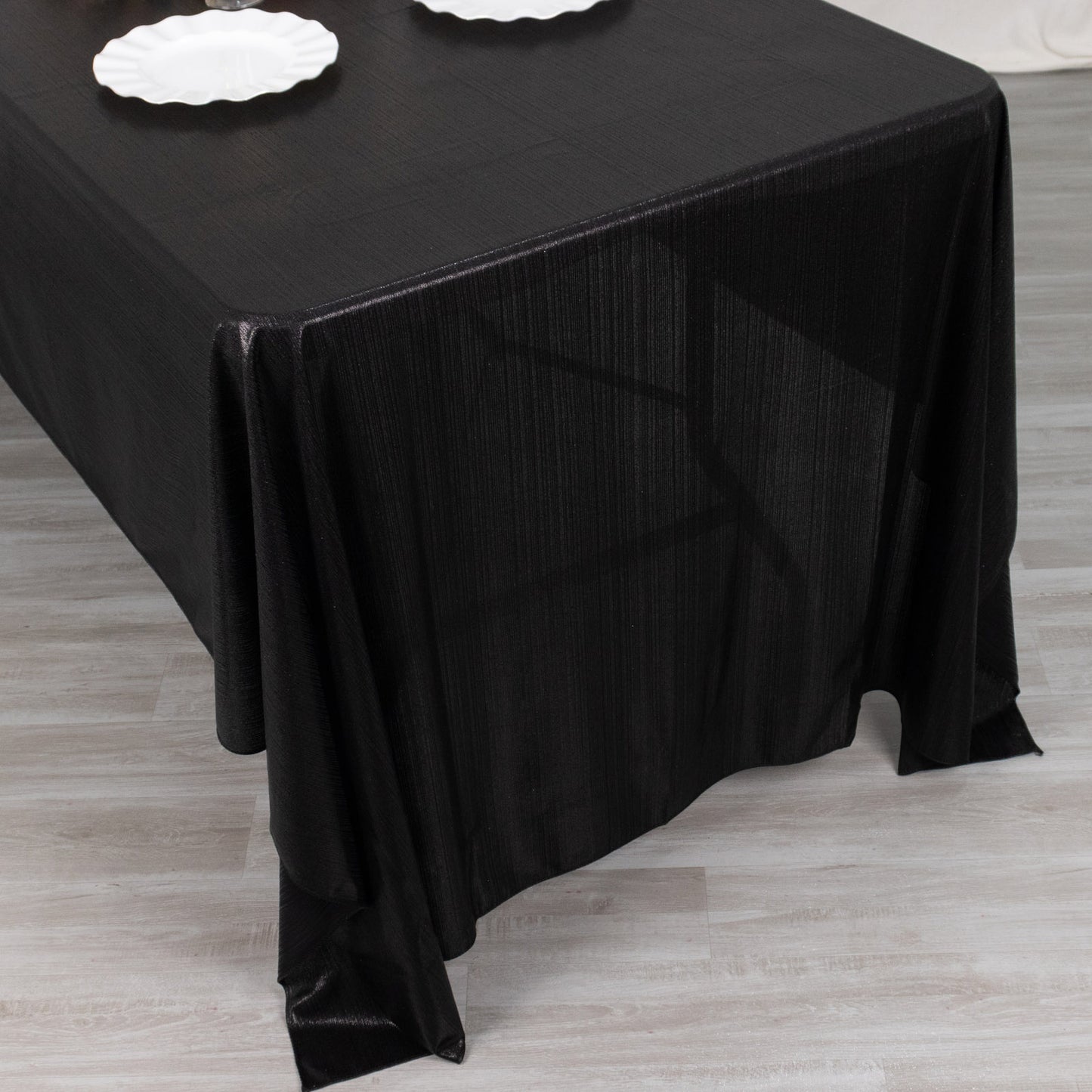 Shiny black polyester tablecloth with sequin dots for elegant table settings.