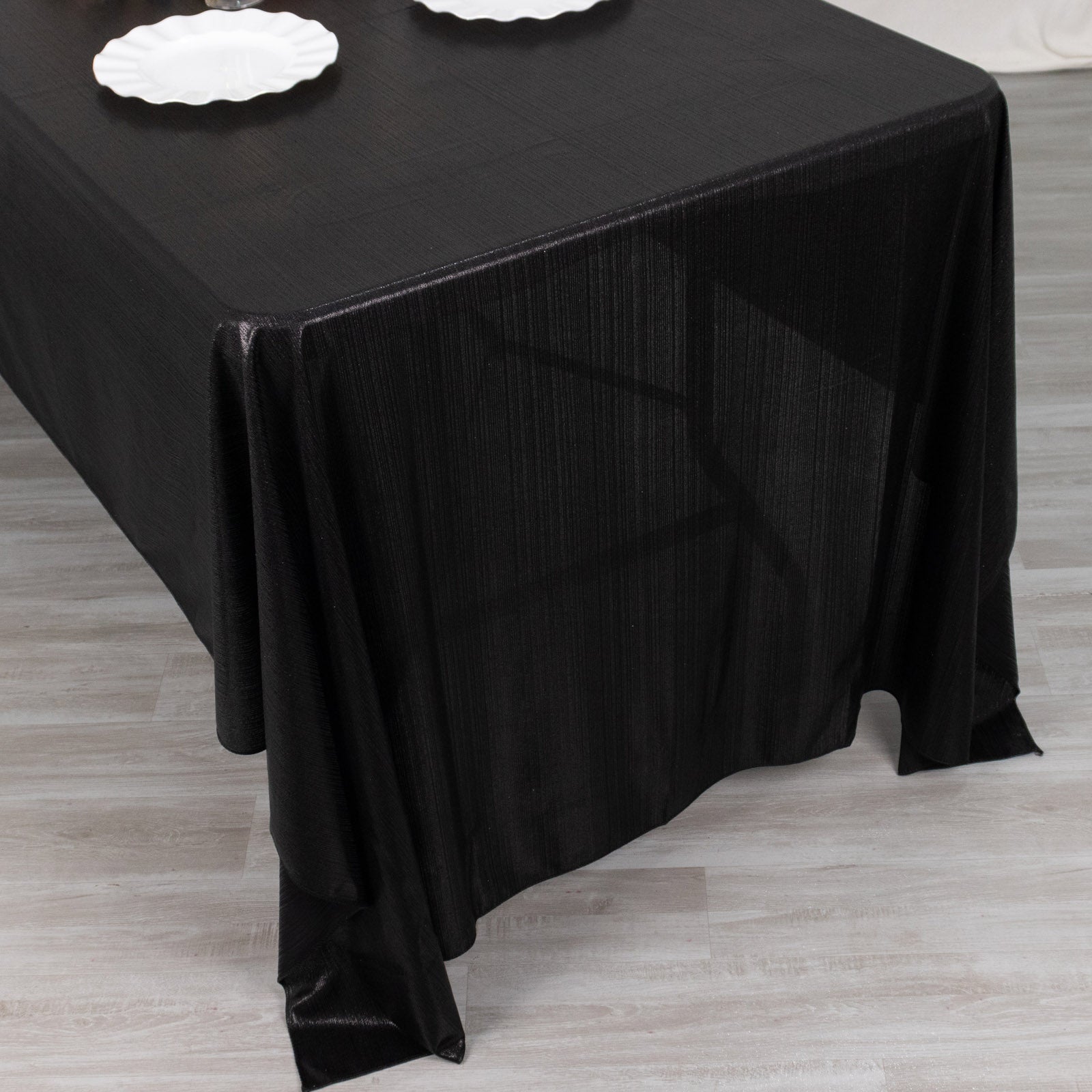 Shiny black polyester tablecloth with sequin dots for elegant table settings.