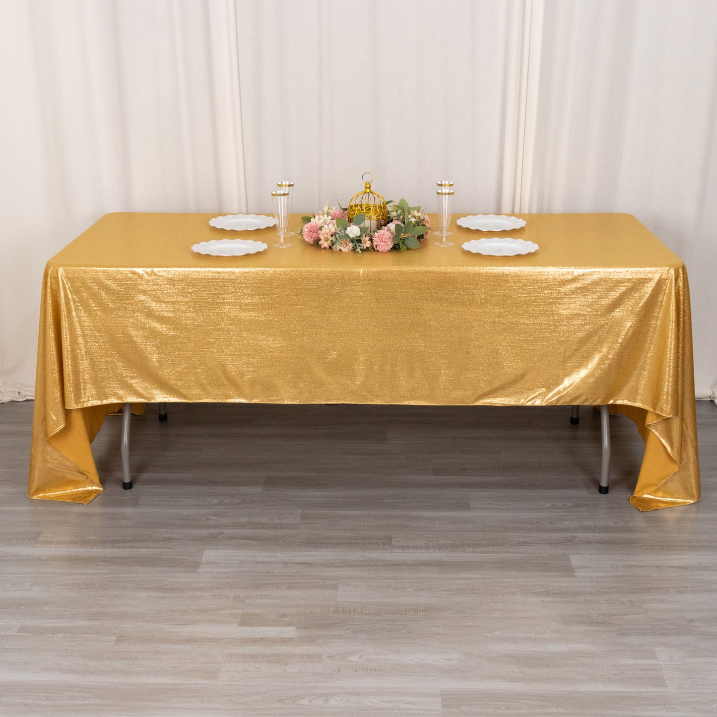 Shiny gold rectangular tablecloth with shimmer sequin dots on a table.