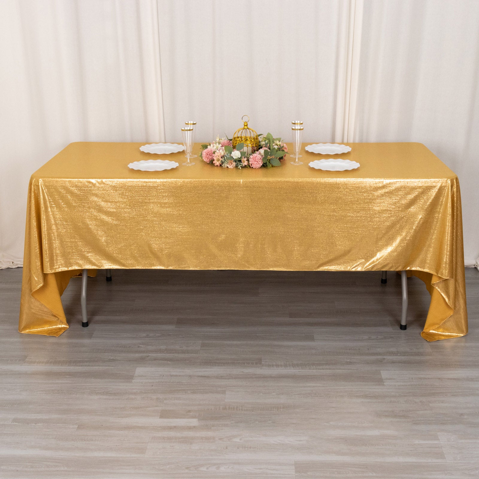 Shiny gold rectangular tablecloth with shimmer sequin dots on a table.