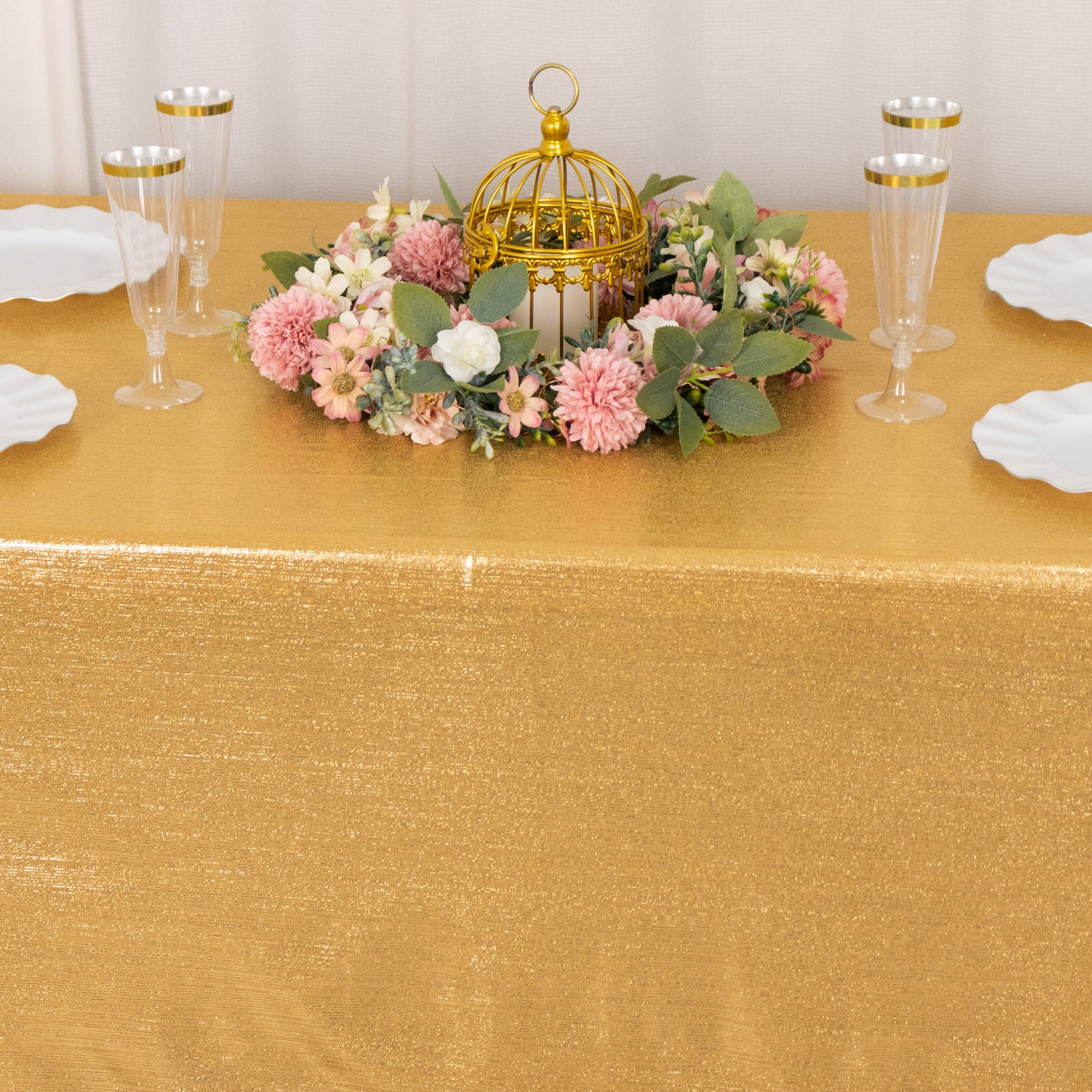 Shiny gold rectangular tablecloth with shimmer sequin dots on a decorated table.