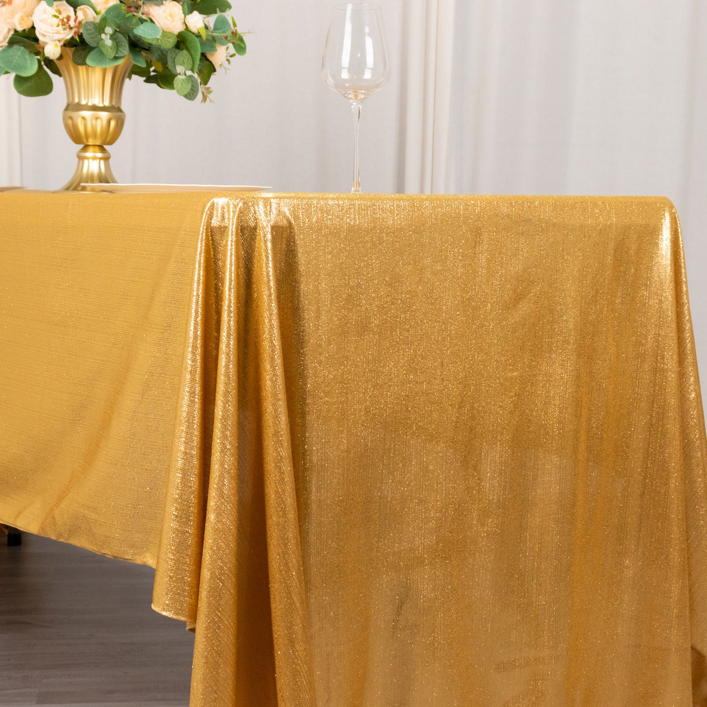 Shiny gold rectangular tablecloth with shimmer sequin dots on a dining table.
