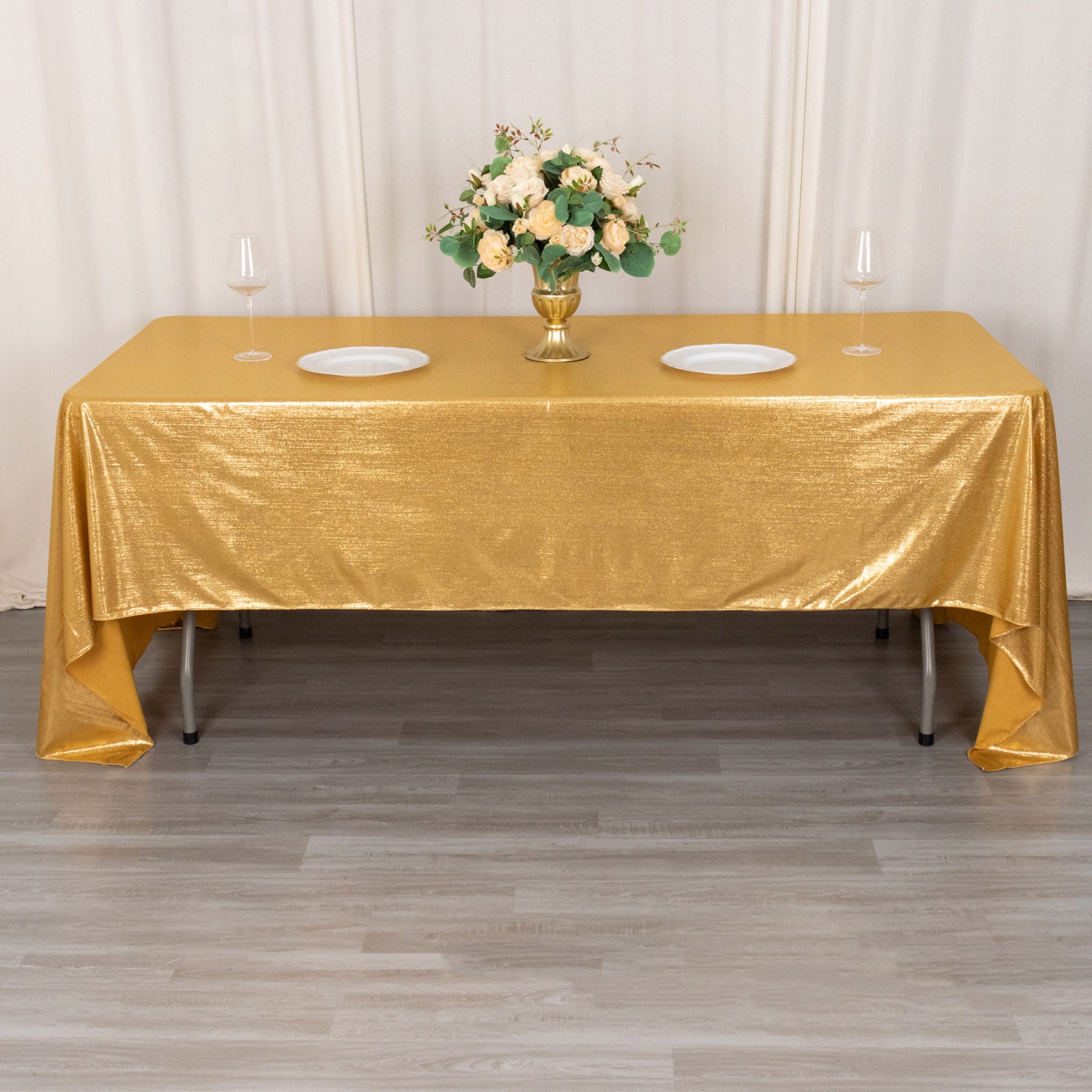 Shiny gold rectangular tablecloth with shimmer sequin dots on a dining table.