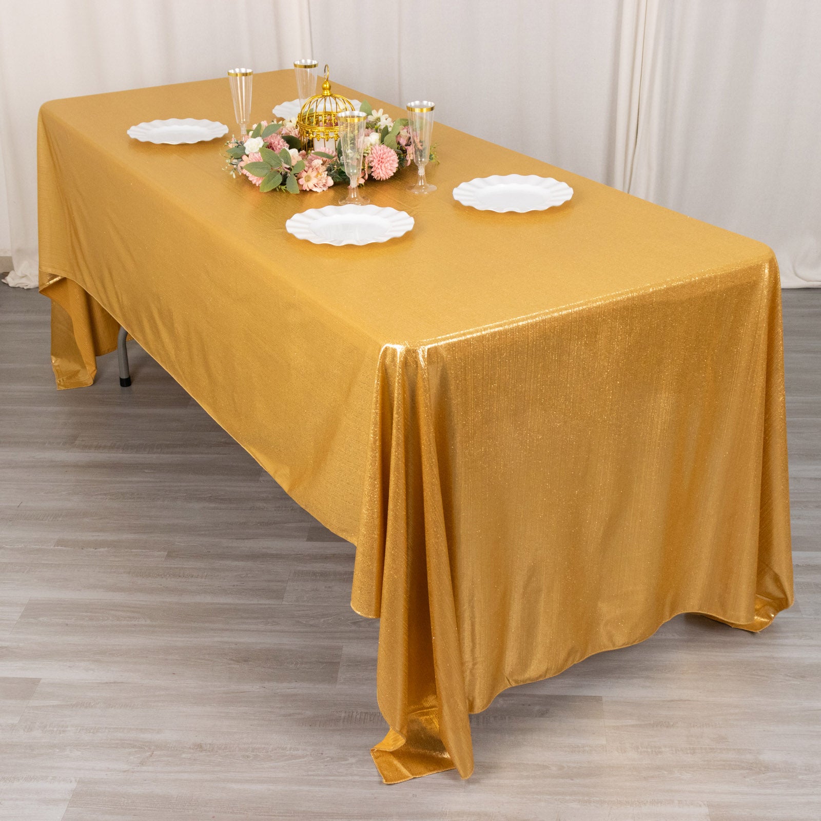 Shiny gold rectangular tablecloth with shimmer sequin dots on a dining table.