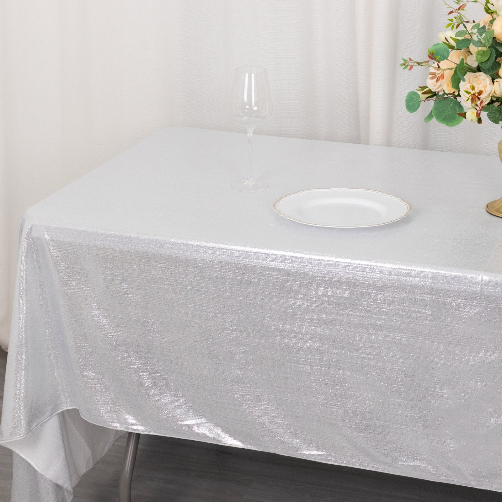 Shiny silver rectangular tablecloth with shimmer sequin dots on a dining table.