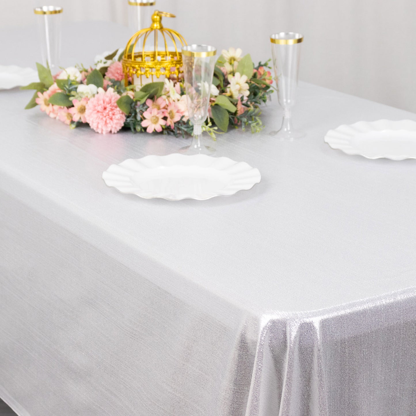 Shiny silver rectangular tablecloth with shimmer sequin dots on a dining table.