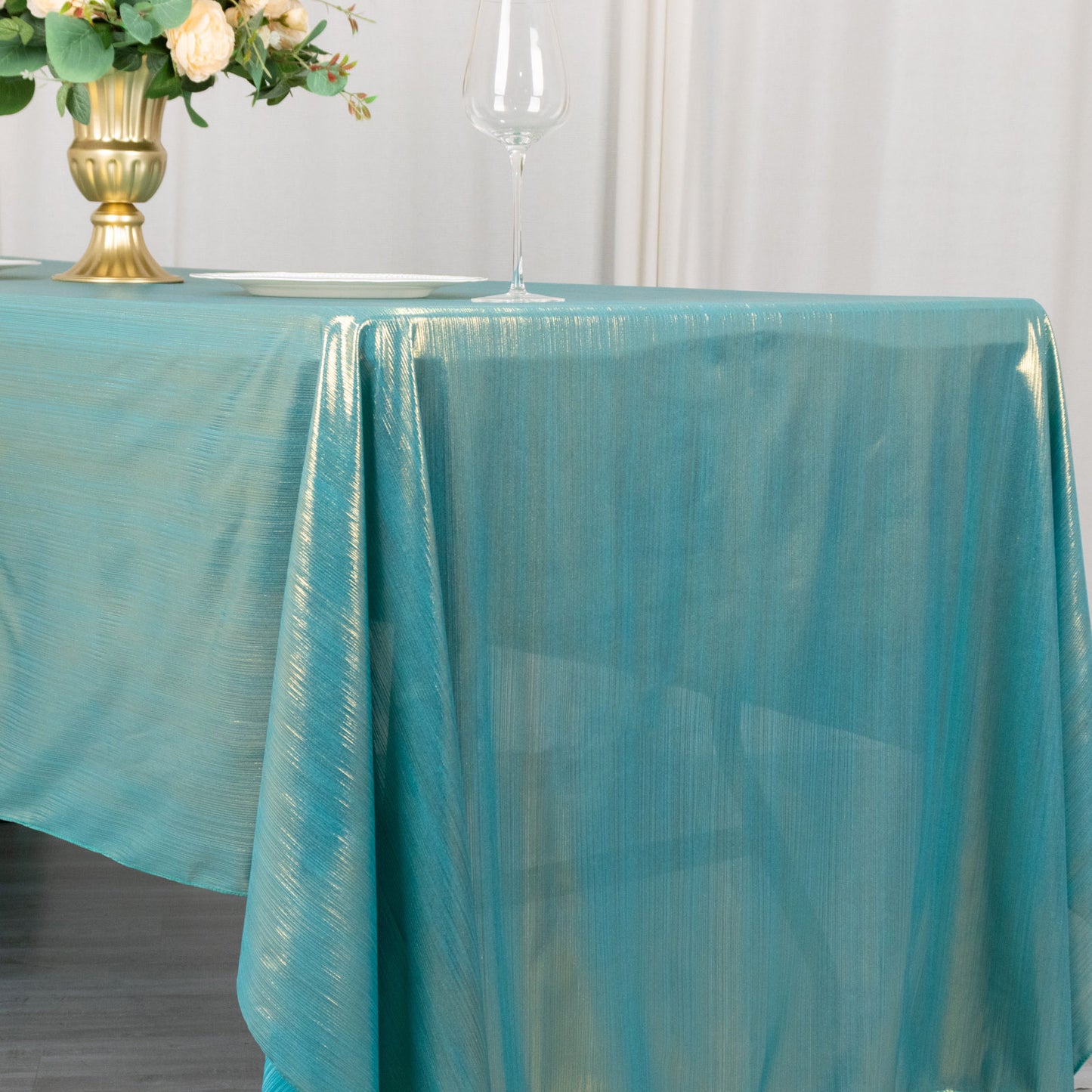 Shiny turquoise tablecloth with shimmer sequin dots on a dining table.