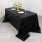 Black shimmer sequin tablecloth on a dining table with floral centerpiece.