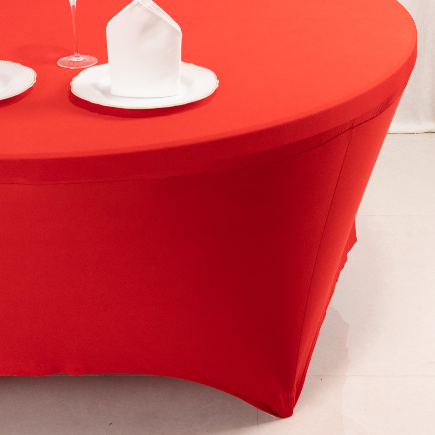 Red round spandex tablecloth fitted for 72 inch tables.