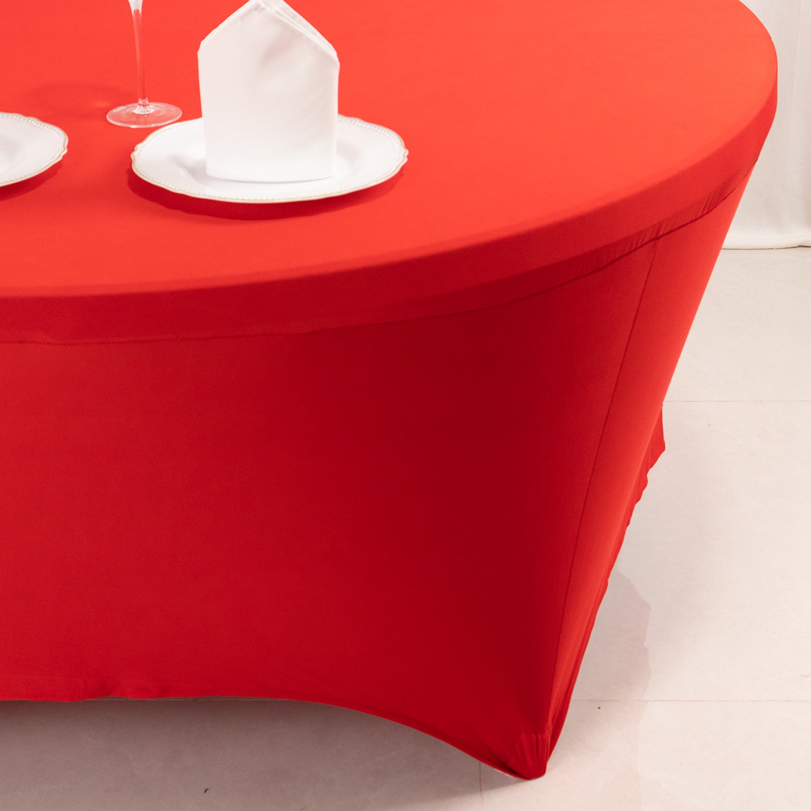 Red round spandex tablecloth fitted for 72 inch tables.