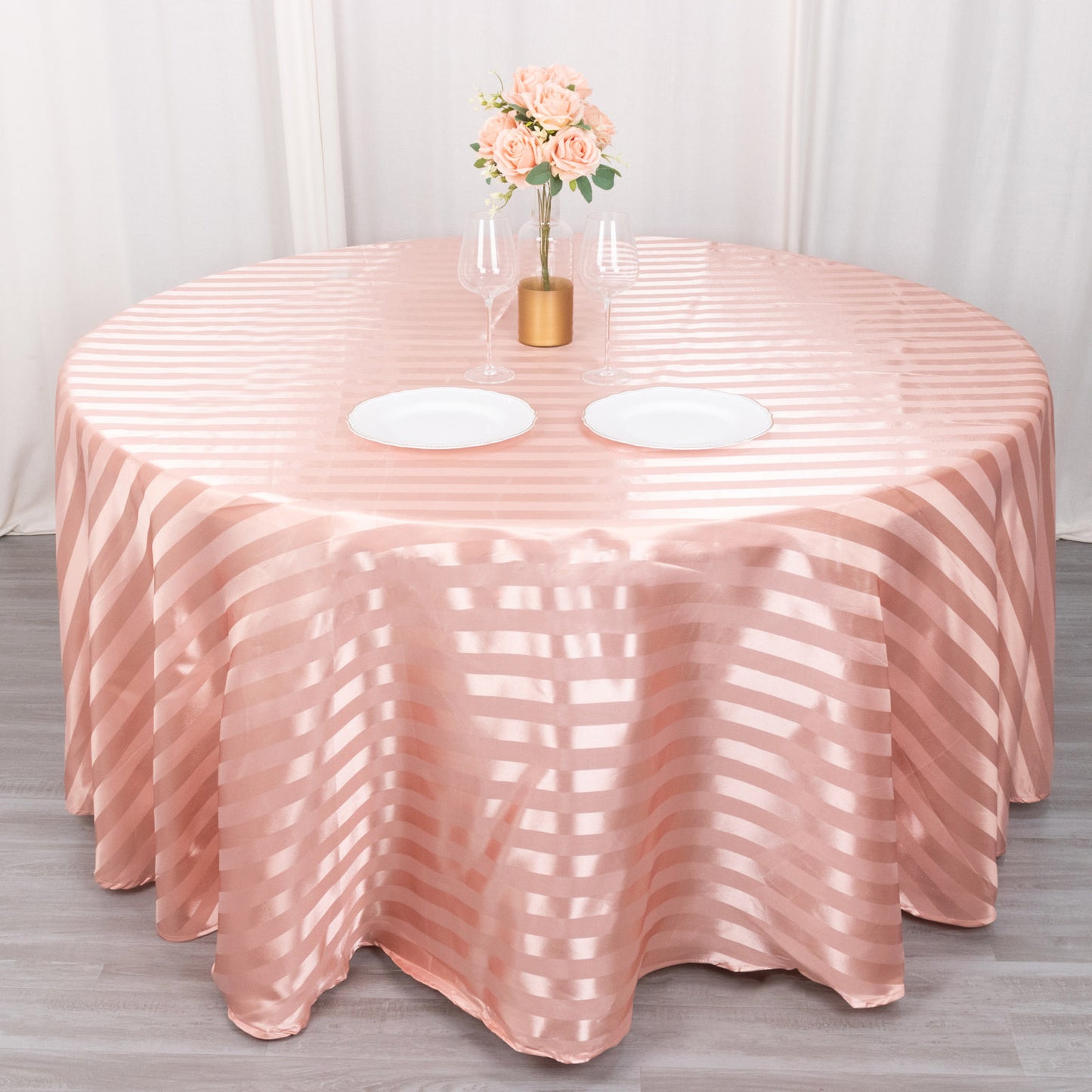 Dusty rose satin stripe seamless round tablecloth on a round table.