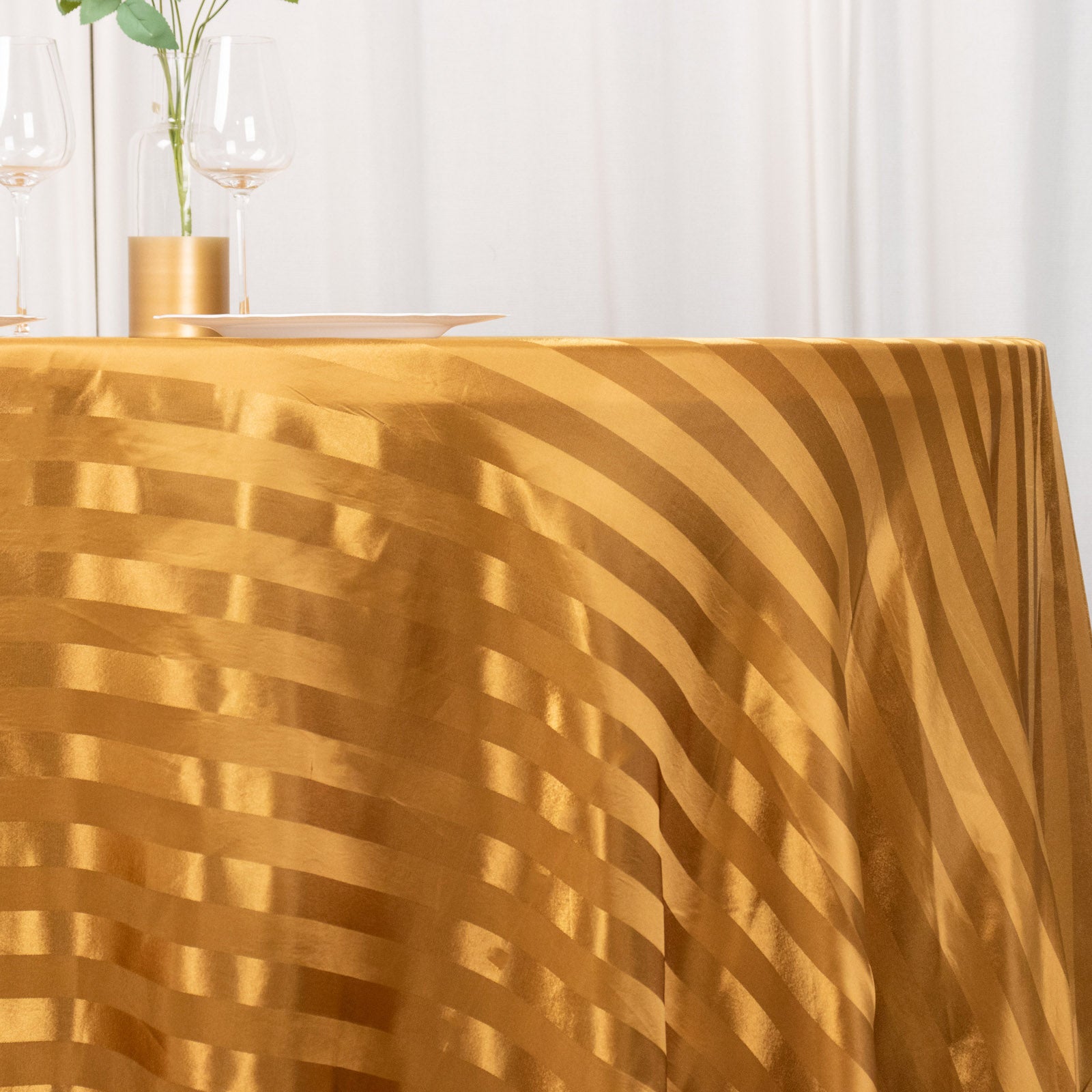 Gold satin stripe seamless round tablecloth on a table.