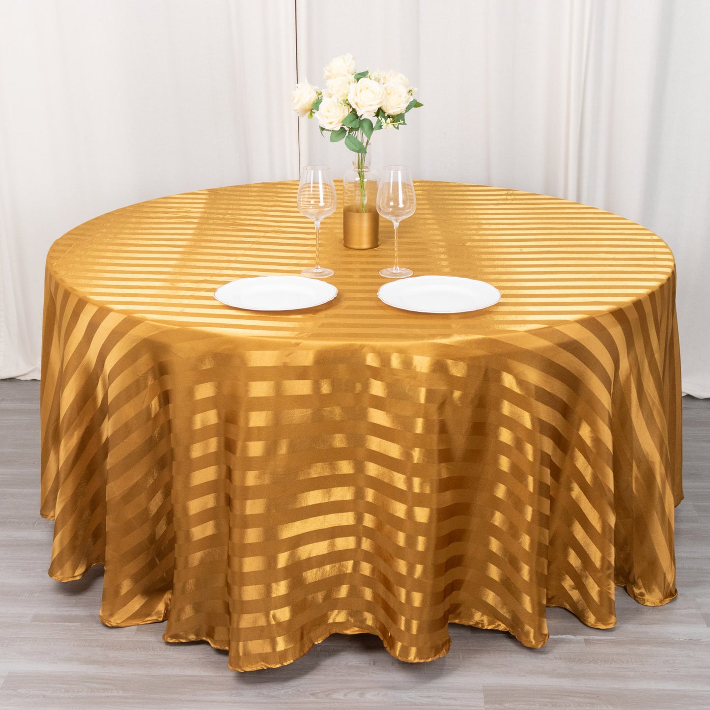 Gold satin stripe seamless round tablecloth on a round table.