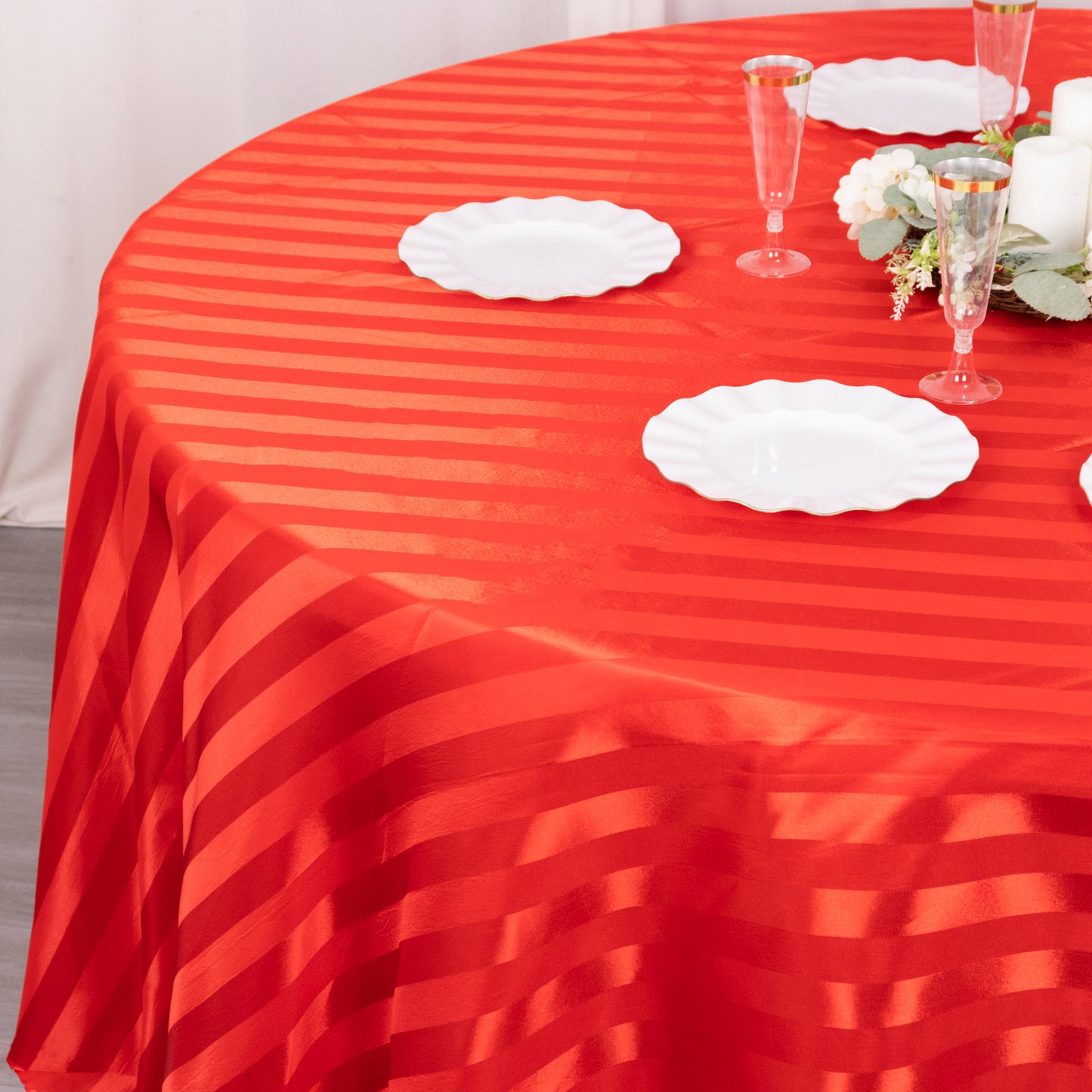 Red satin stripe round tablecloth on a dining table.