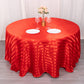 120" red satin stripe seamless round tablecloth on a table with flowers and dinnerware.