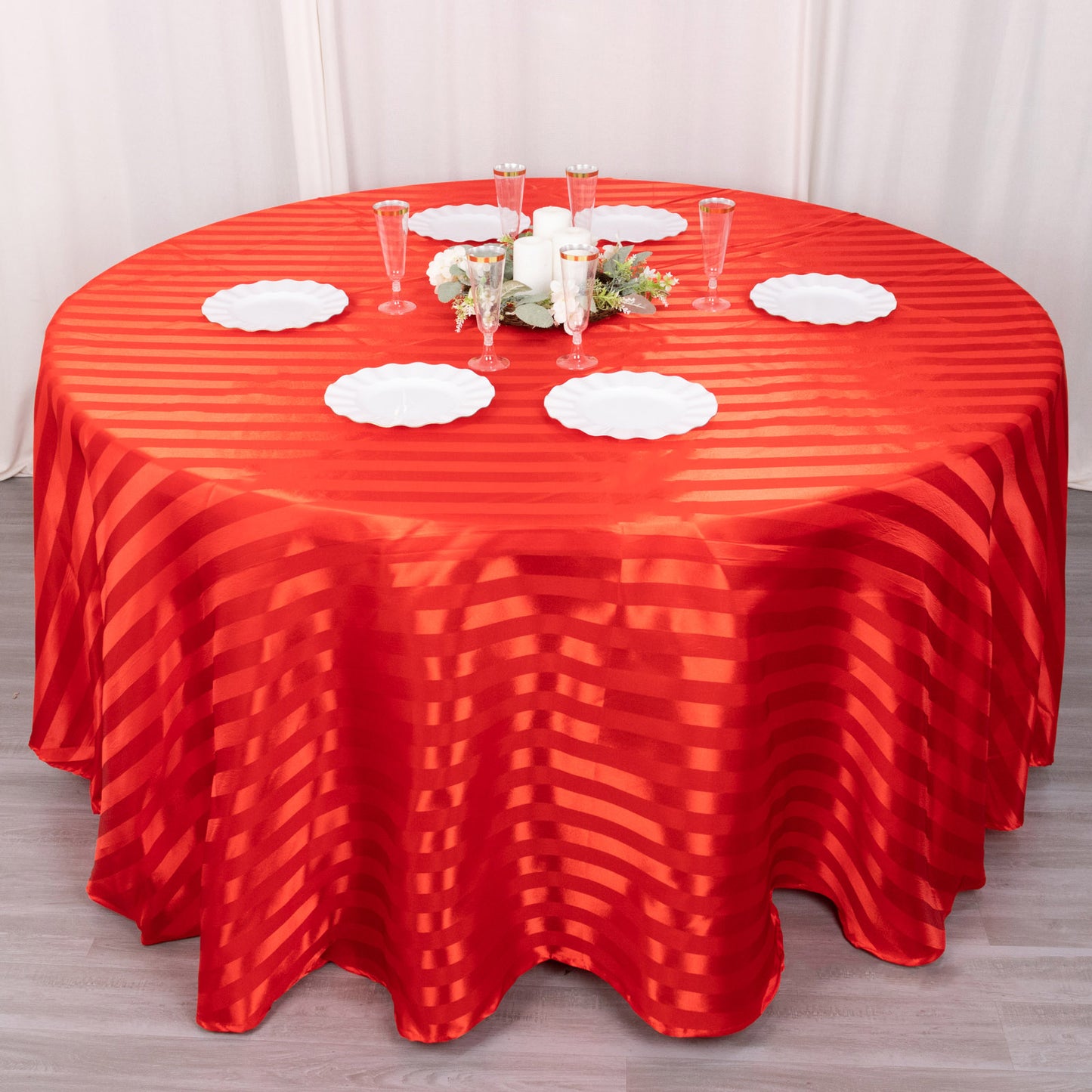 120" red satin stripe seamless round tablecloth on a table setting.