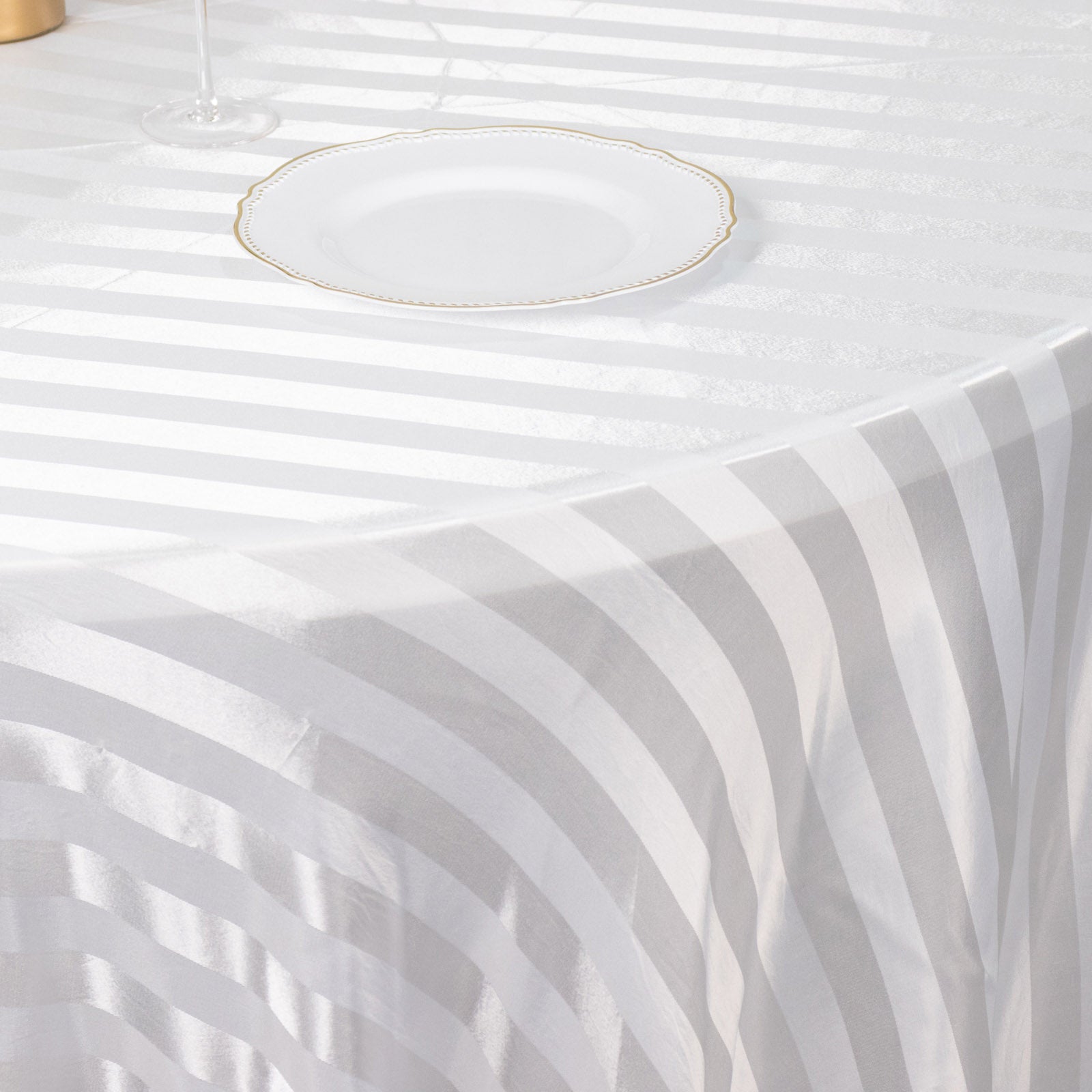 White satin stripe seamless round tablecloth on a table.