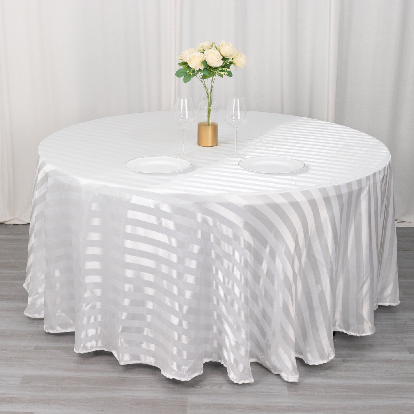 White satin stripe seamless round tablecloth on a table.