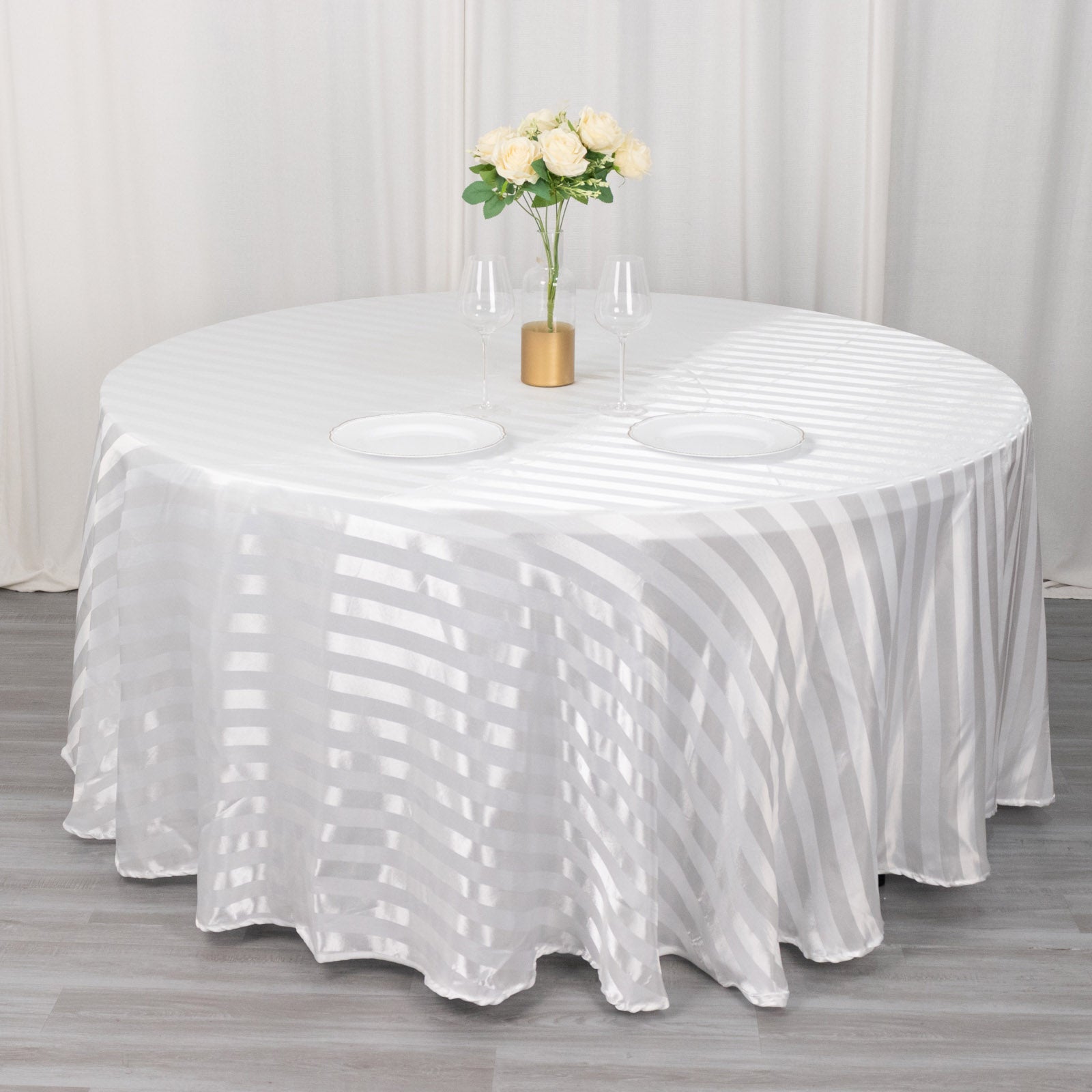 White satin stripe seamless round tablecloth on a table.