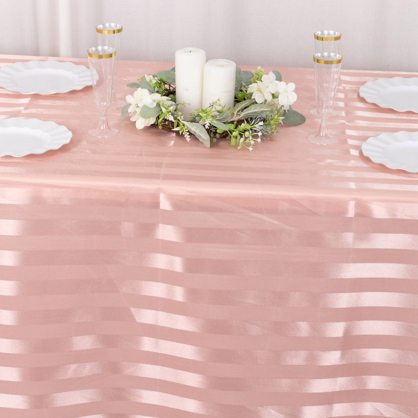 Dusty rose satin stripe tablecloth on a decorated dining table.