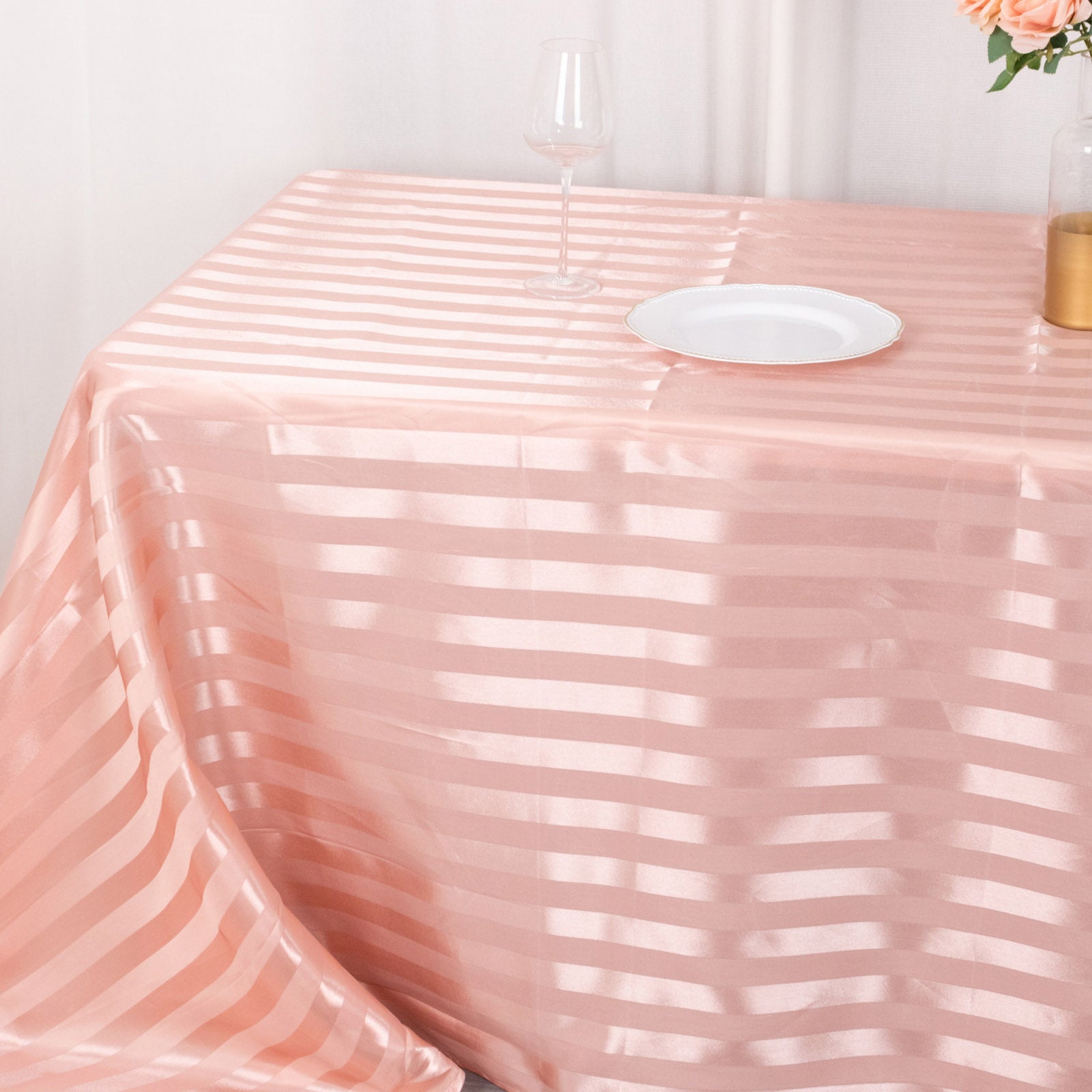 Dusty rose satin stripe tablecloth on a dining table.