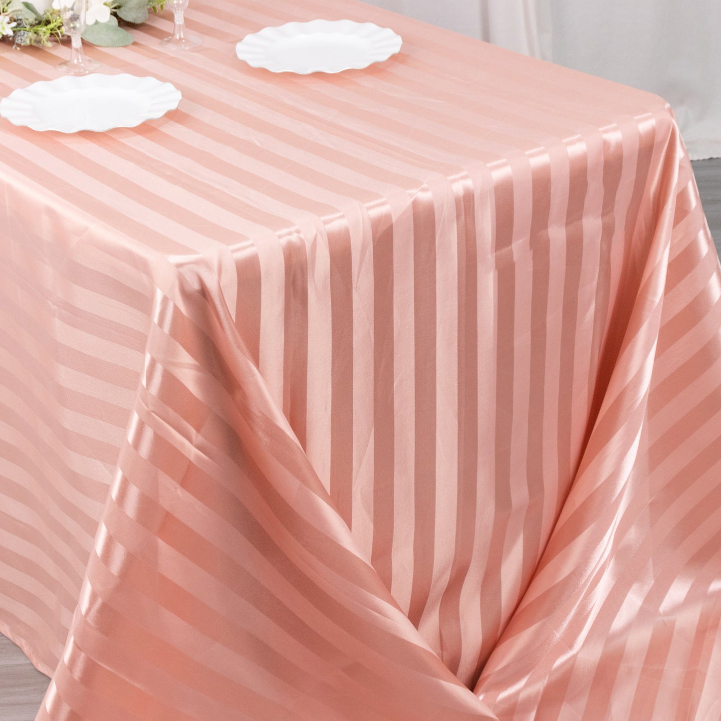 Dusty rose satin stripe tablecloth on a dining table.