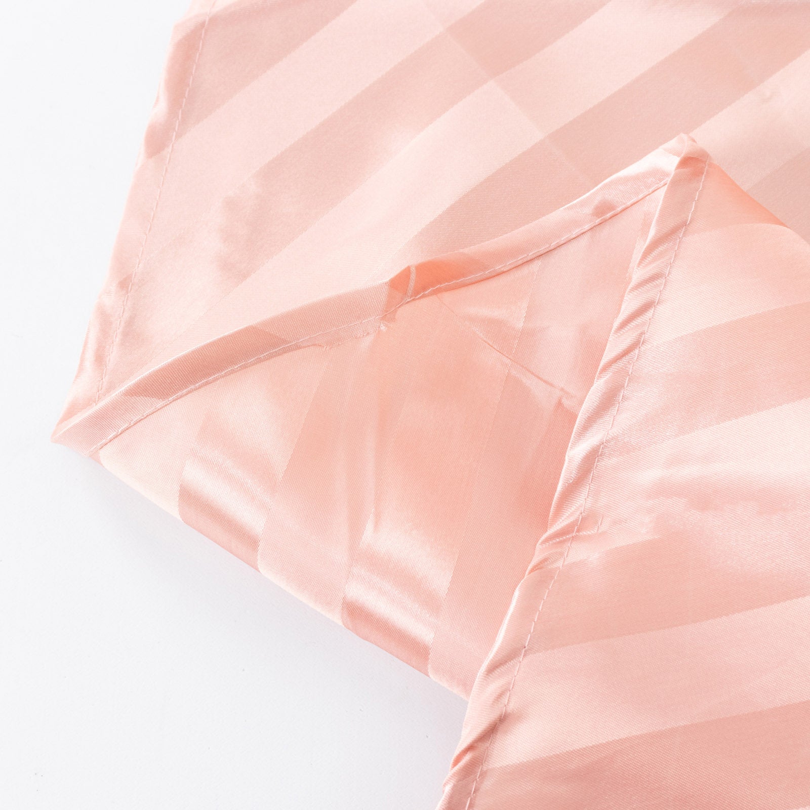 Dusty rose satin stripe tablecloth on a white surface.