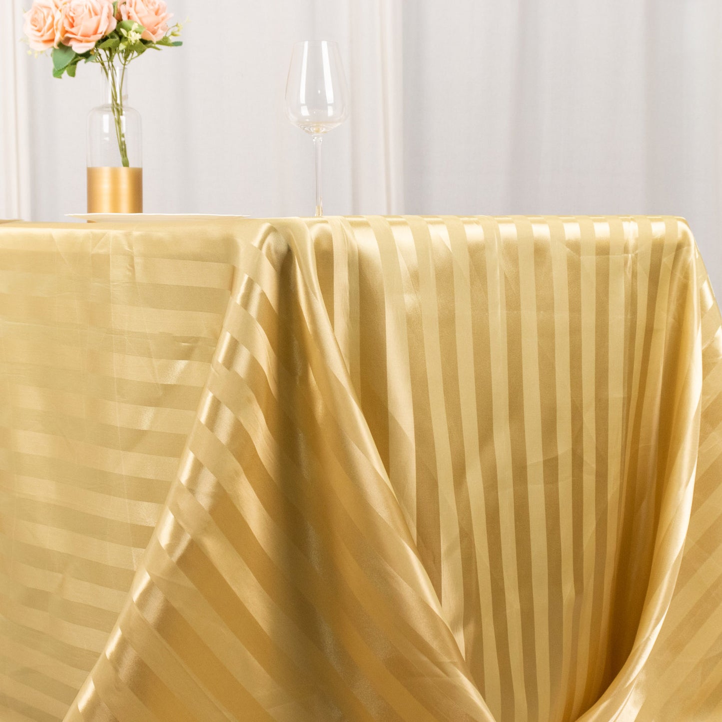 Champagne satin stripe tablecloth for elegant dining settings.