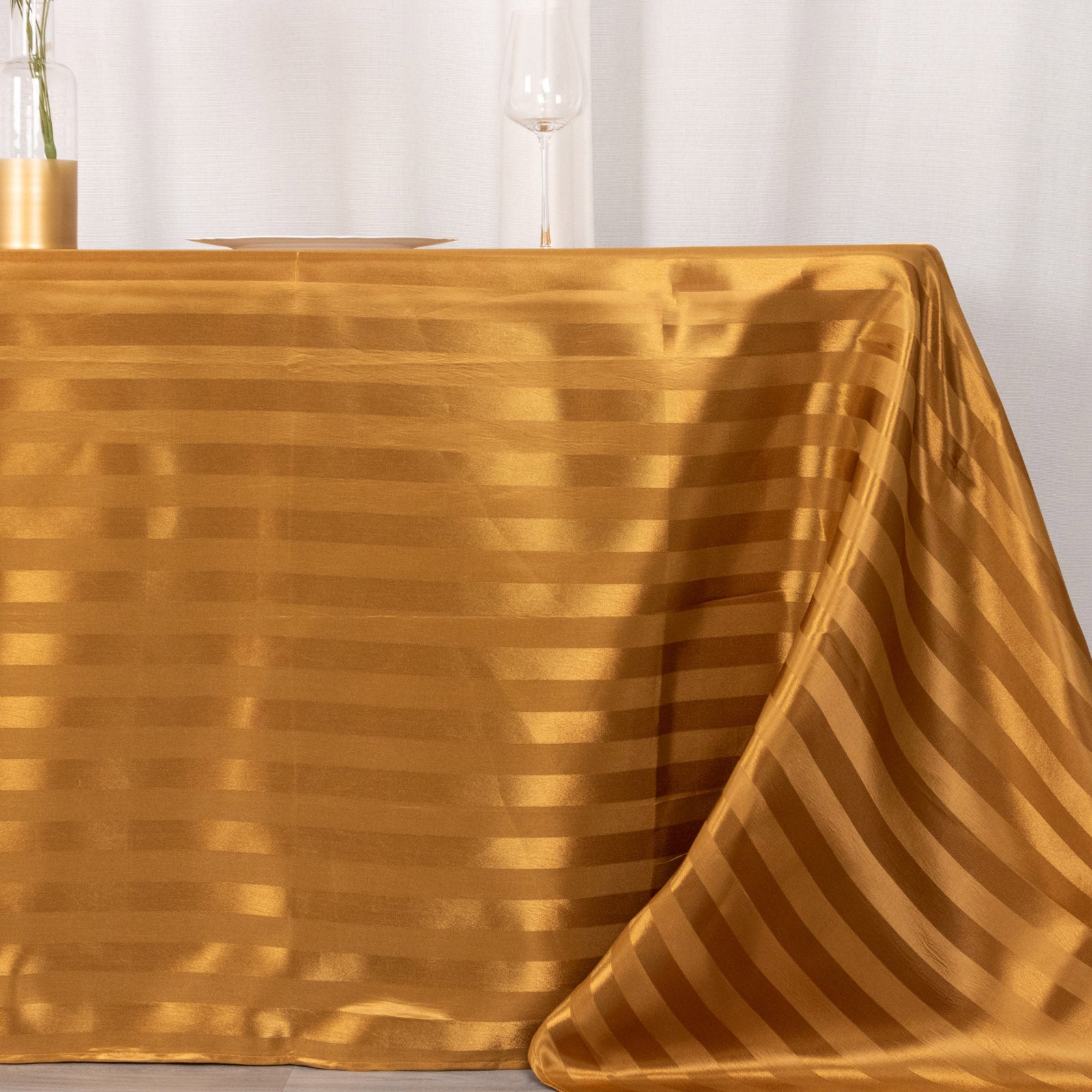 Gold satin stripe tablecloth on a dining table.